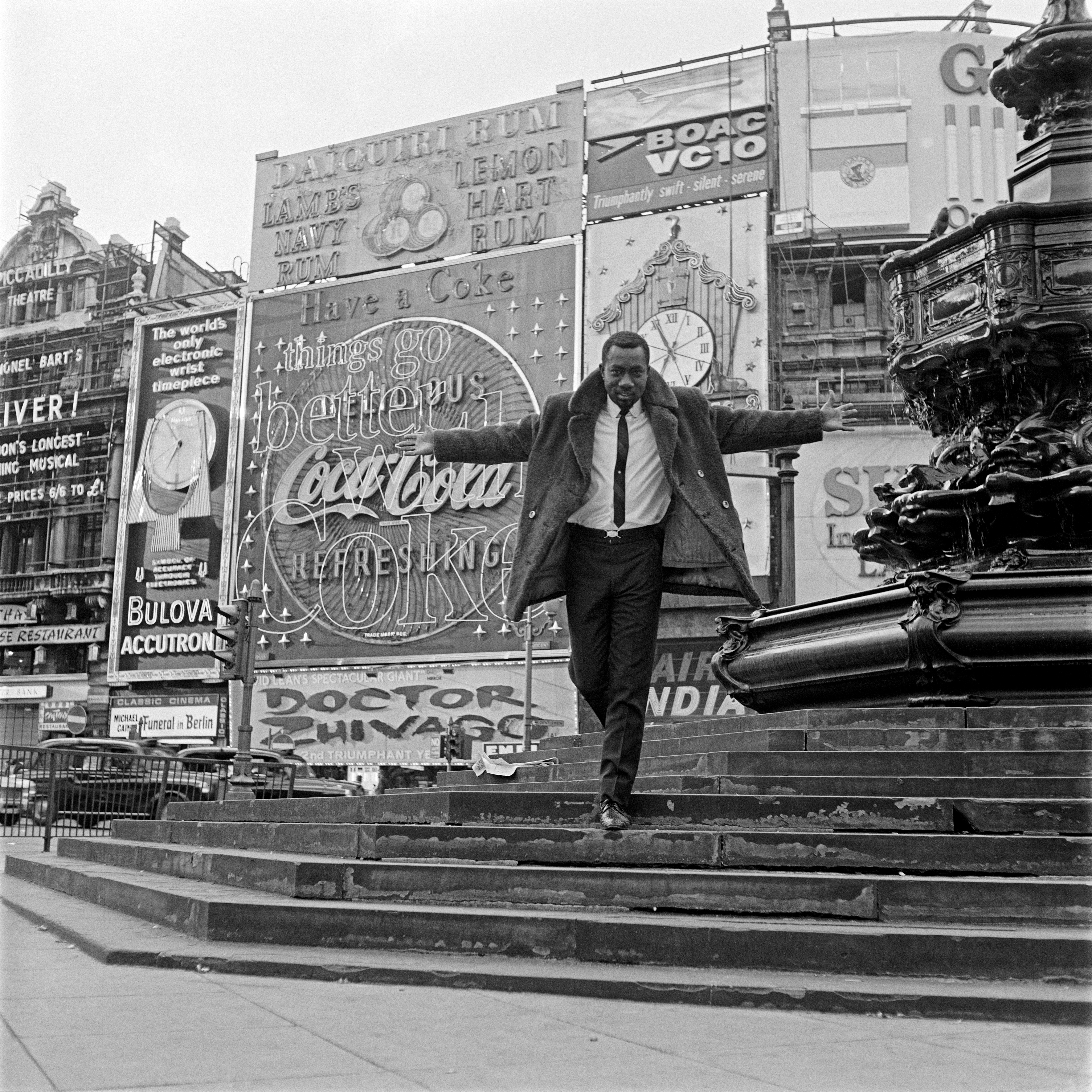 A photo of a person walking down some stairs with his arms up and to the side.