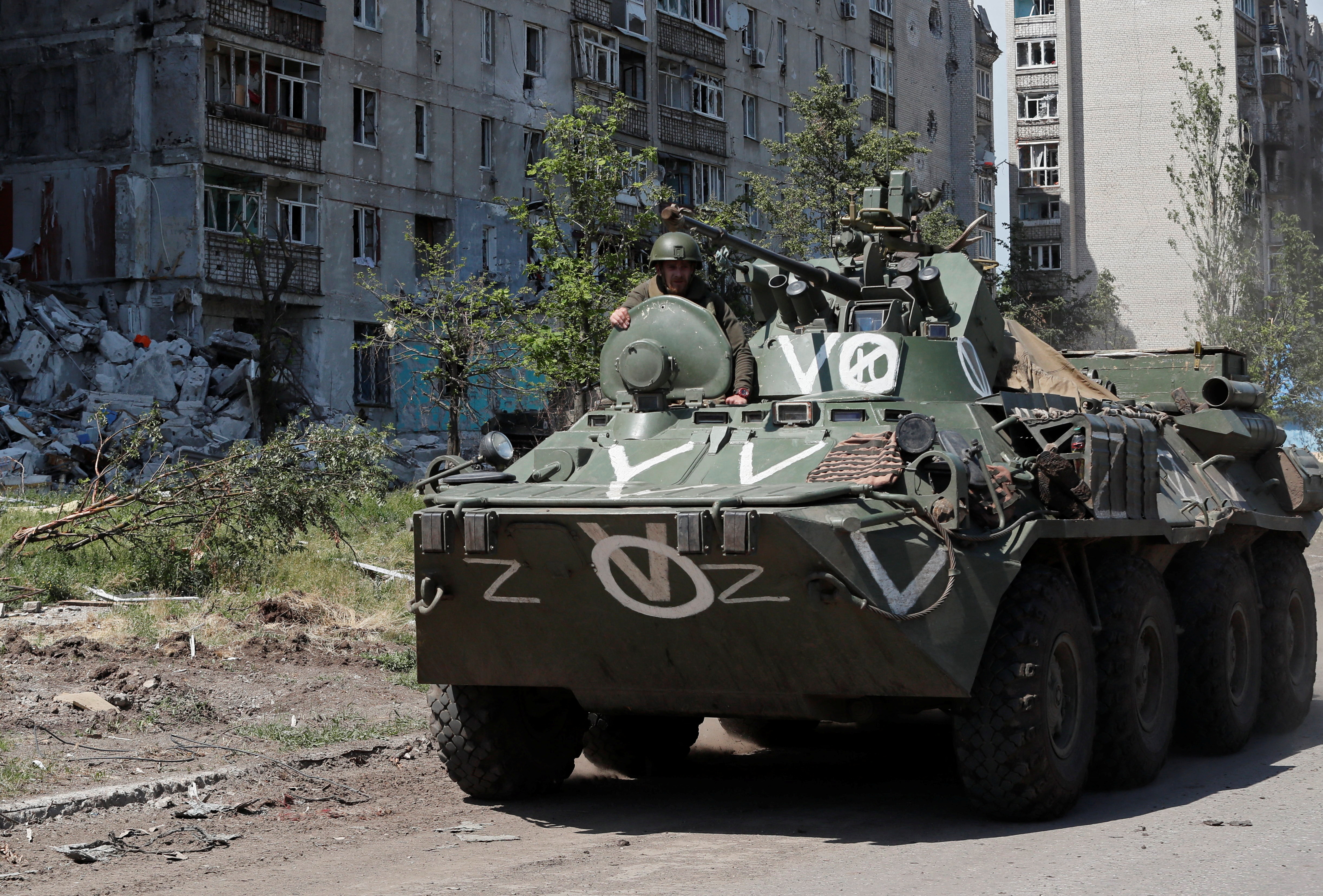 A service member of pro-Russian troops rides on top of an armoured personnel carrier during Ukraine-Russia conflict in the town of Popasna in the Luhansk Region, Ukraine.