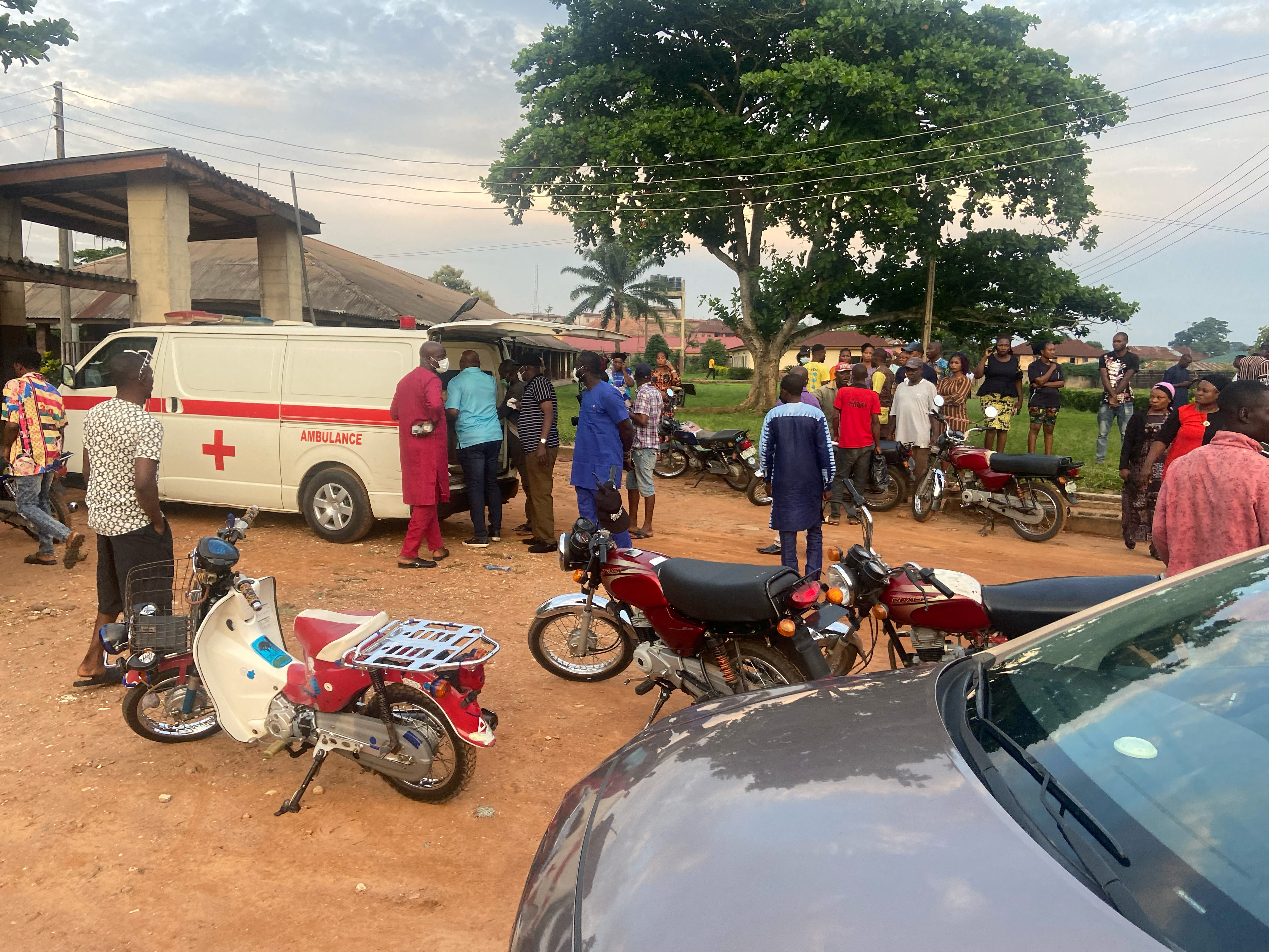 Relatives of churchgoers who were attacked by gunmen during Sunday's church service gather as health workers attend to victims after the attack at St. Francis Catholic Church