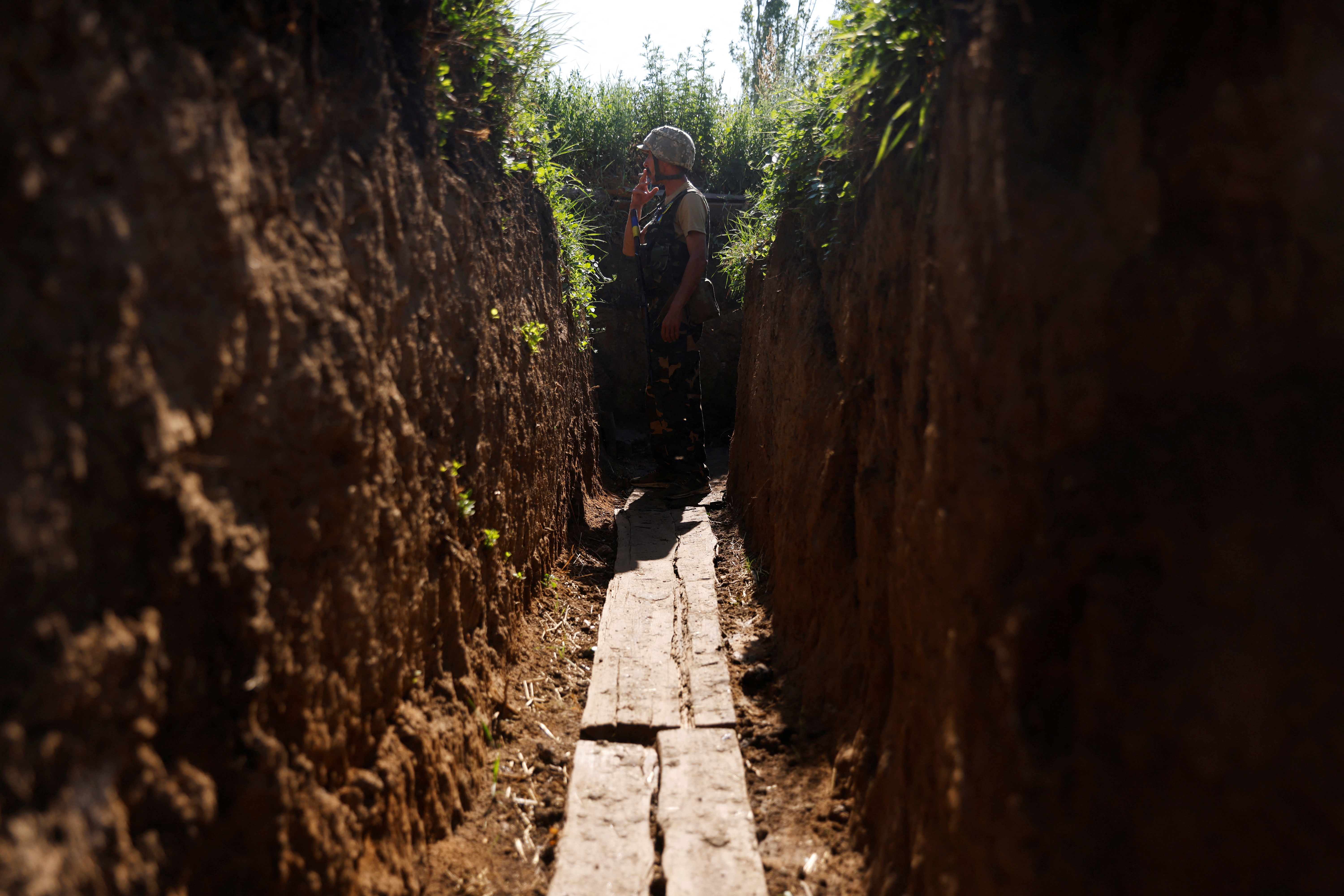 A Ukrainian soldier is seen in a trench