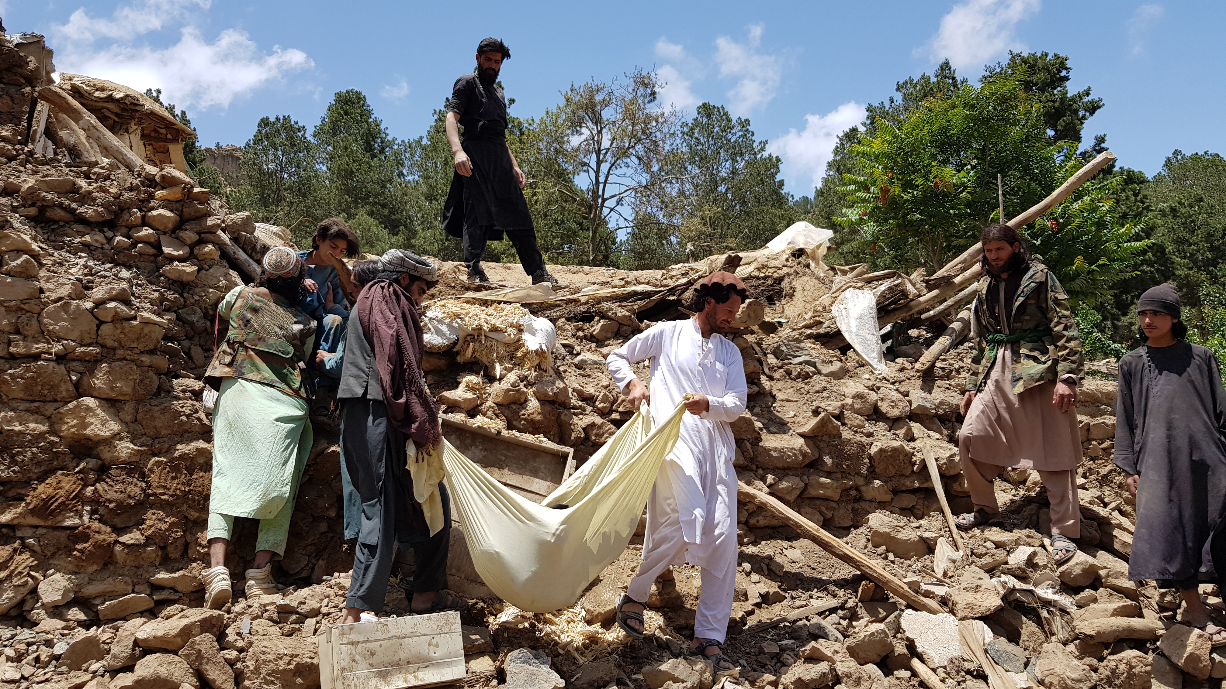 Residents wrap a body in a blanket after the 5.9 magnitude earthquake that struck eastern Afghanistan.