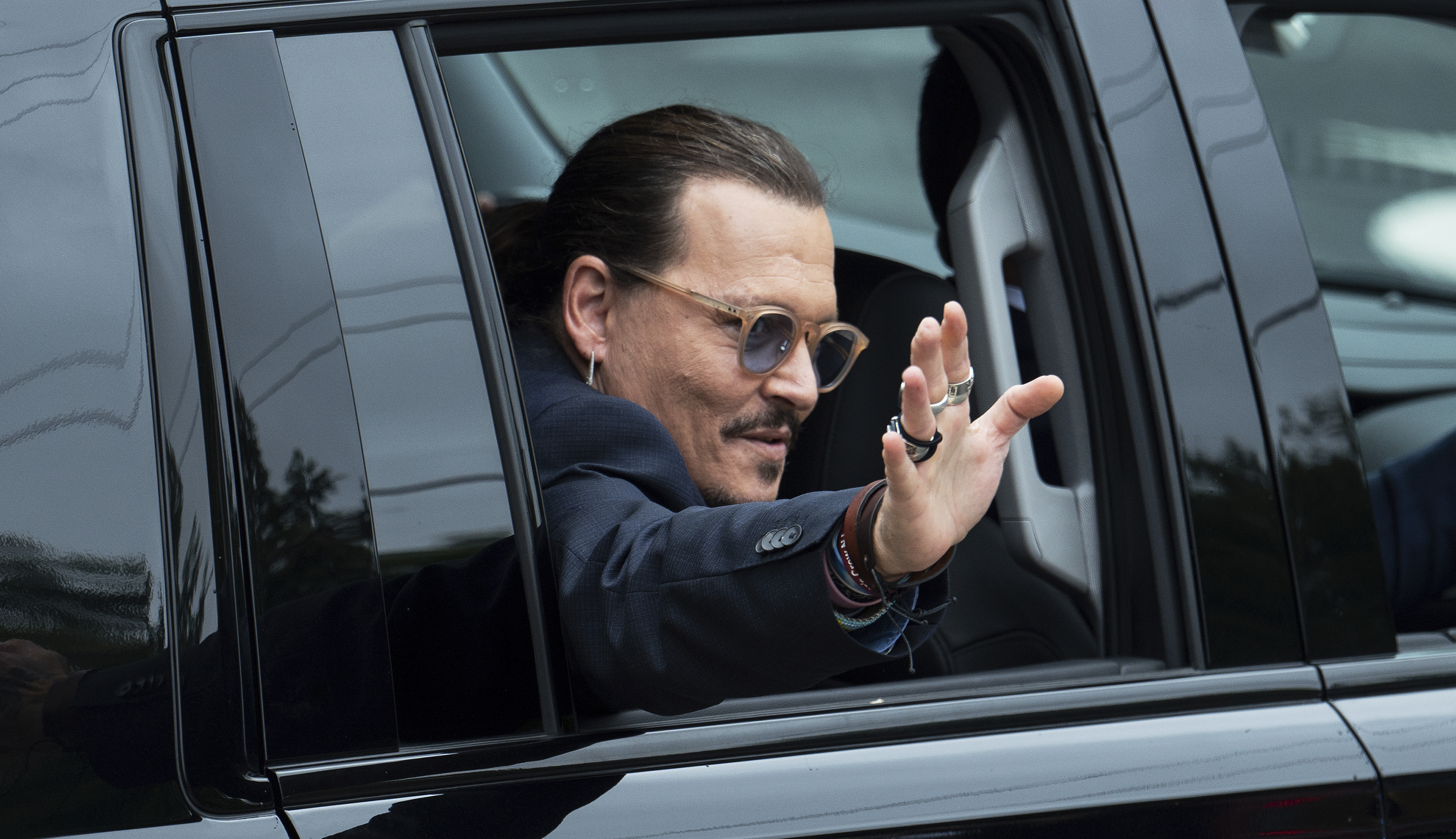 Actor Johnny Depp waves to supporters as he departs the Fairfax County Courthouse Friday, May 27, 2022 in Fairfax, Va. A jury heard closing arguments in Johnny Depp's high-profile libel lawsuit against ex-wife Amber Heard. Lawyers for Johnny Depp and Amber Heard made their closing arguments to a Virginia jury in Depp's civil suit against his ex-wife.(AP Photo/Craig Hudson)