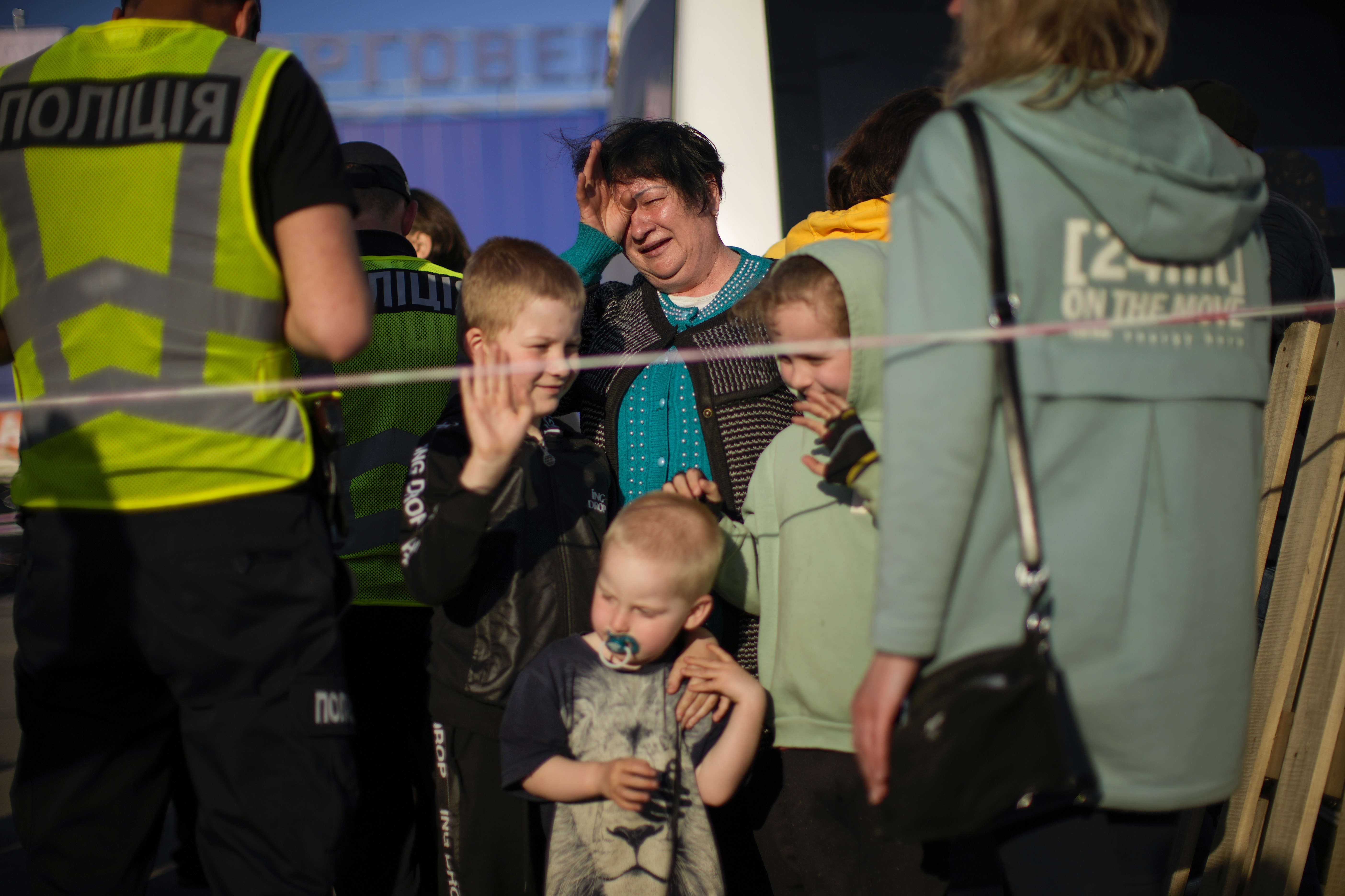 A woman cries as she and her three grandchildren arrive at a reception centre for the displaced in Zaporizhzhia, Ukraine.