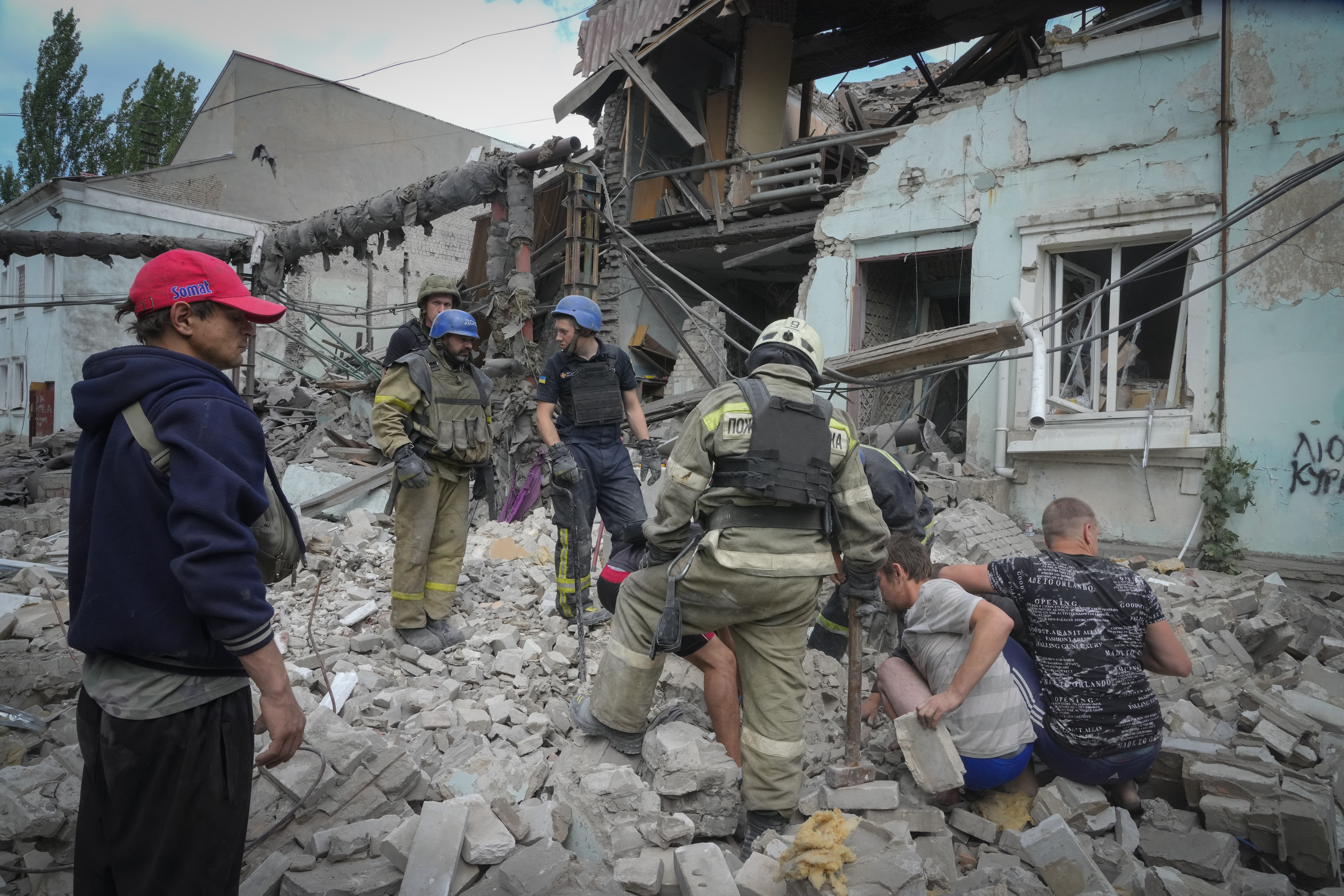 Search and rescue workers and residents remove a body from under the rubble of a building after a Russian air raid in Lysychansk, Luhansk region, Ukraine.