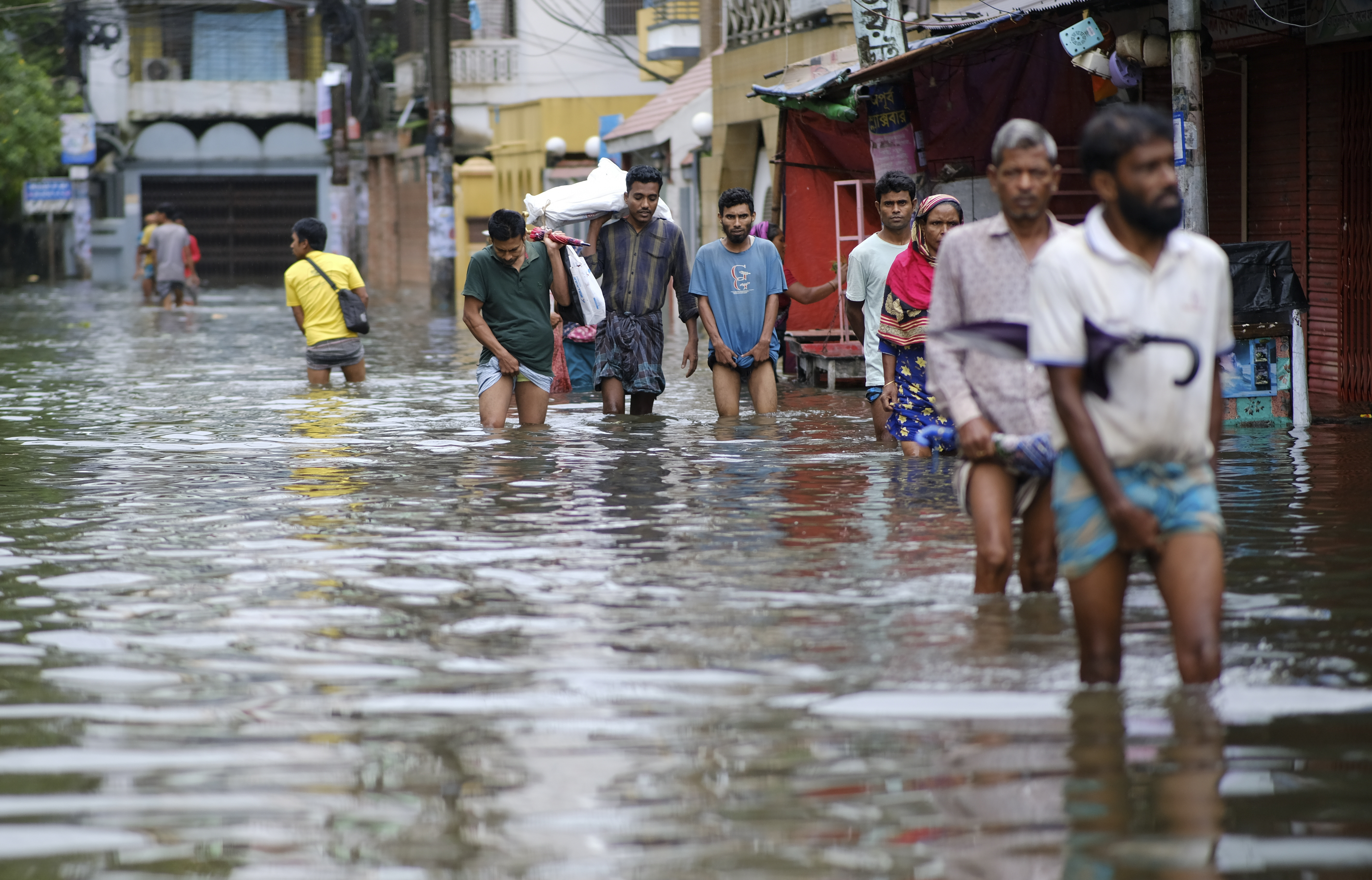 People wade through flood waters in Sylhet