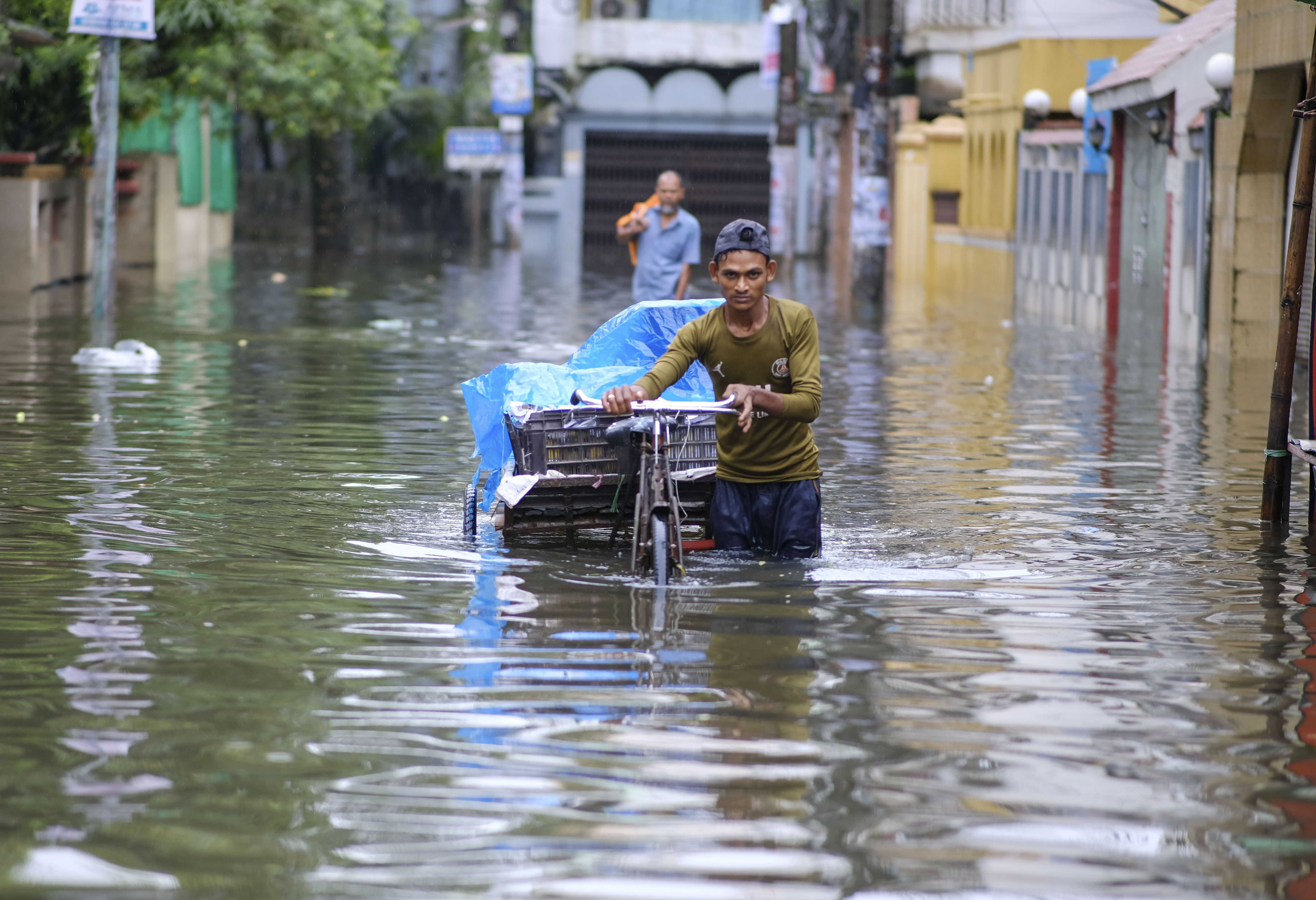 A man pushes his cart through floodwaters