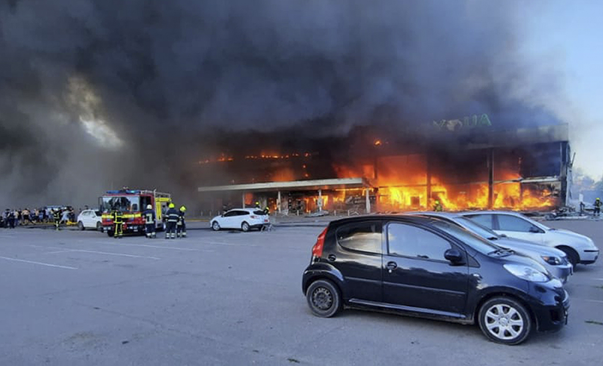 In this image made from video provided by Ukrainian State Emergency Service, firefighters work to extinguish a fire at a shopping center burned after a rocket attack in Kremenchuk, Ukraine, Monday, June 27, 2022