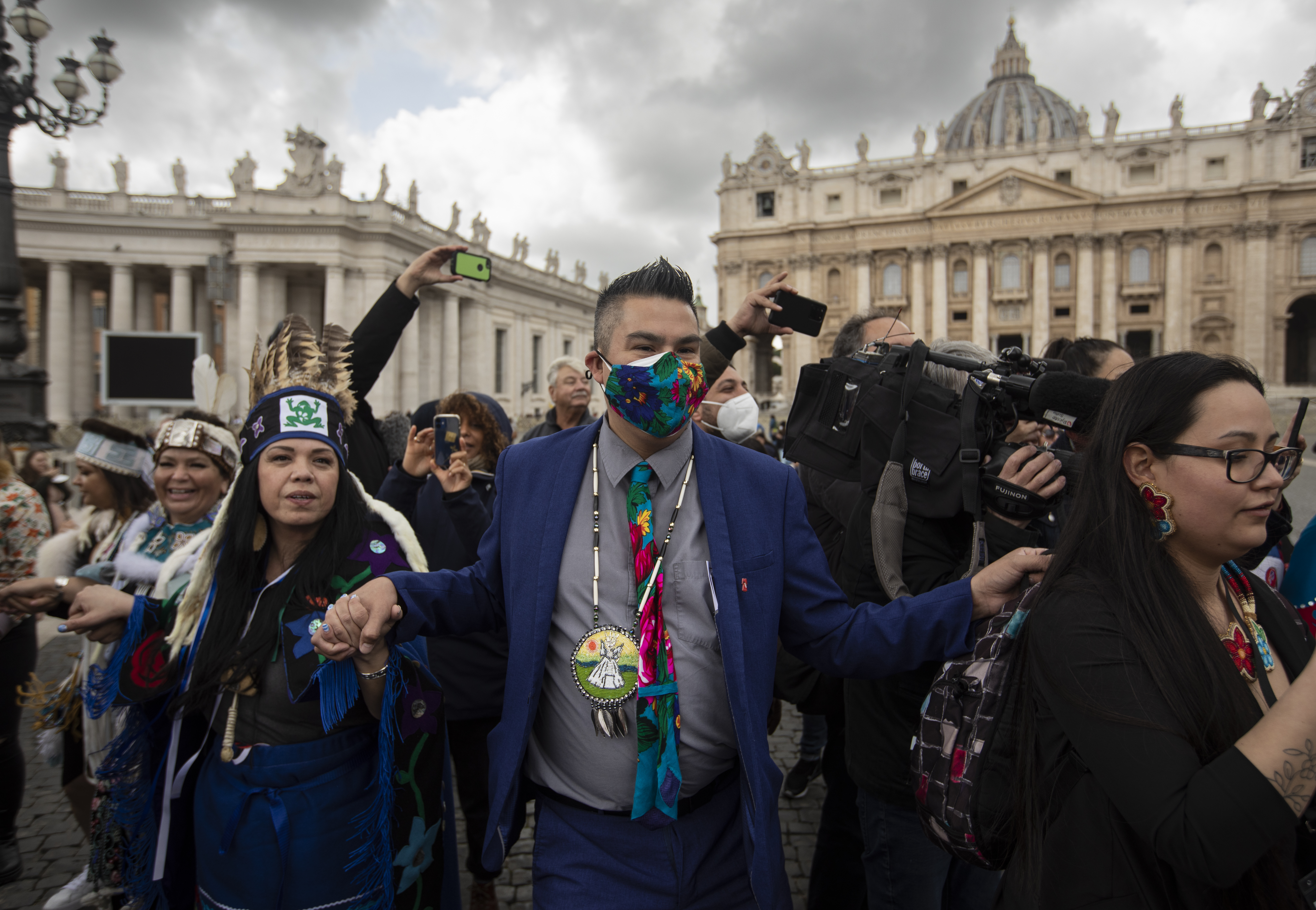A photo of Andy Alook dancing in St. Peter’s Square in Rome Italy with a crowd of people around him.