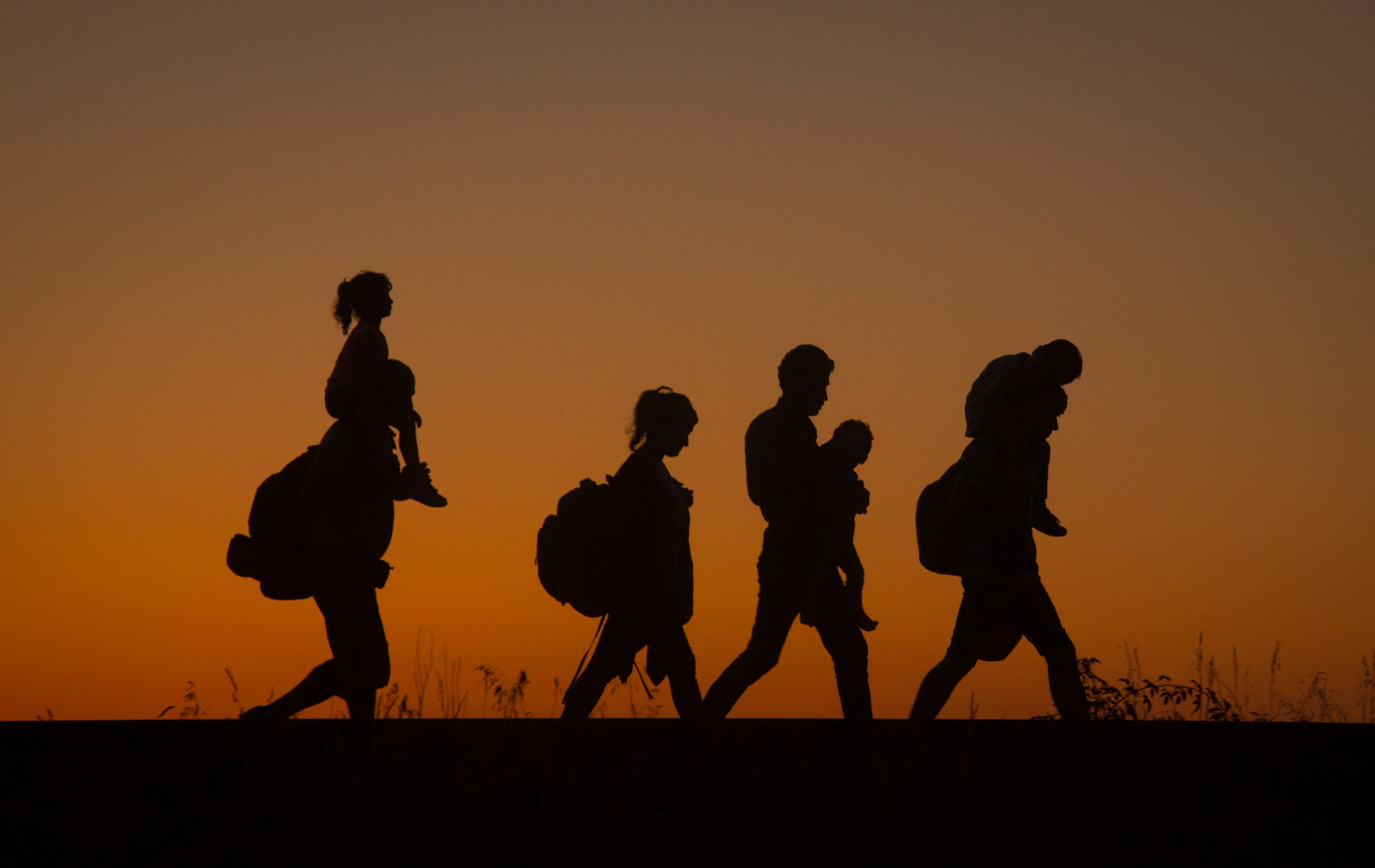 Refugees walking along a railway in Europe