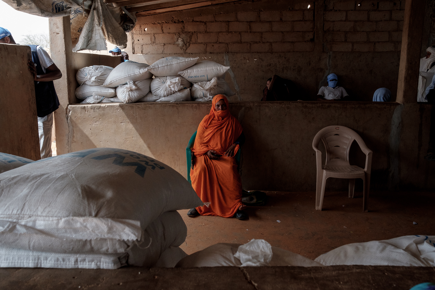 A Malian refugee waits at a food distribution centre in Mbera camp for their allocation of food assistance and feminine hygenie products