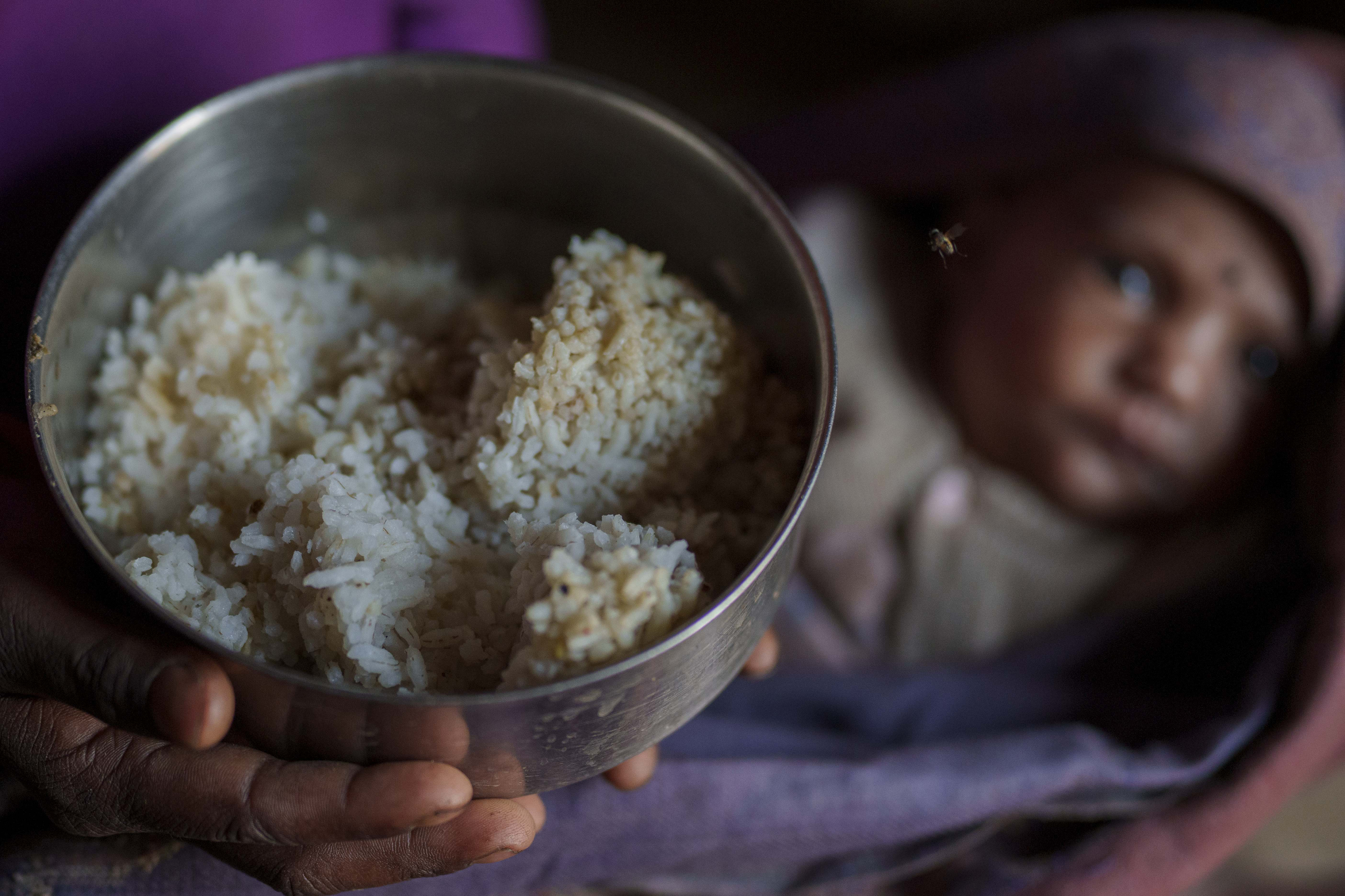 A woman shows the food which is only rice and salt that she feed to her children in Muktikot