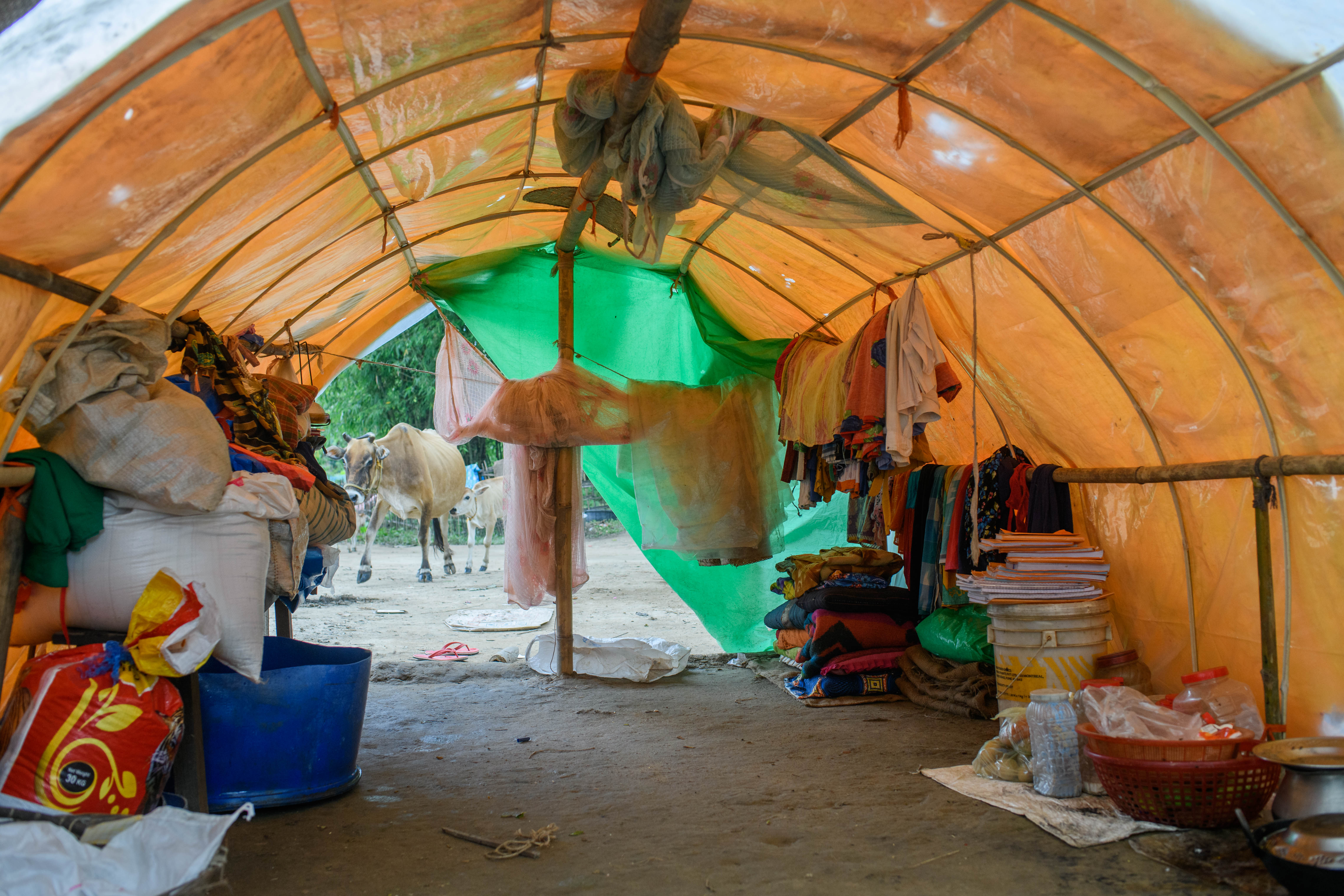 Textbooks of school children and sacks of grain that was salvaged from the flood in one of the tents of the relief camp in Kholahat reserve forest in Morigaon district of Assam