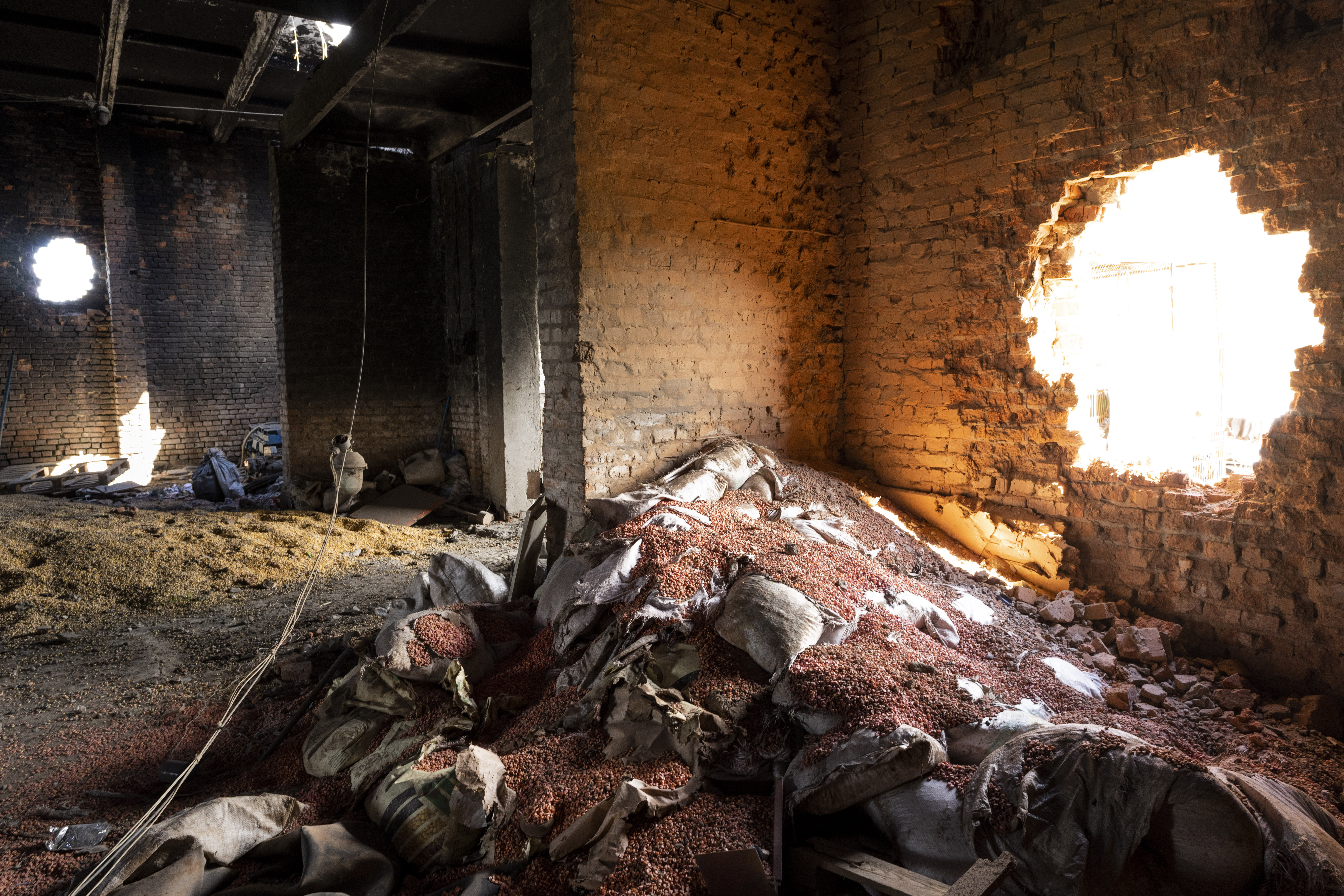 Scattered grain sits inside a warehouse damaged by Russian attacks.