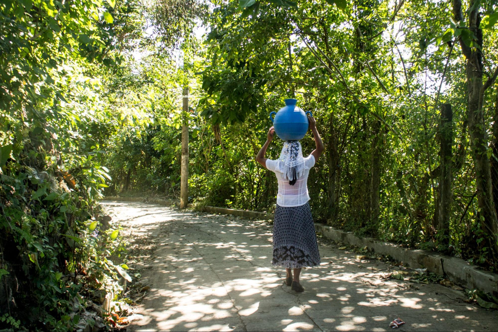 A Salvadoran woman collects water by foot in El Salvador.