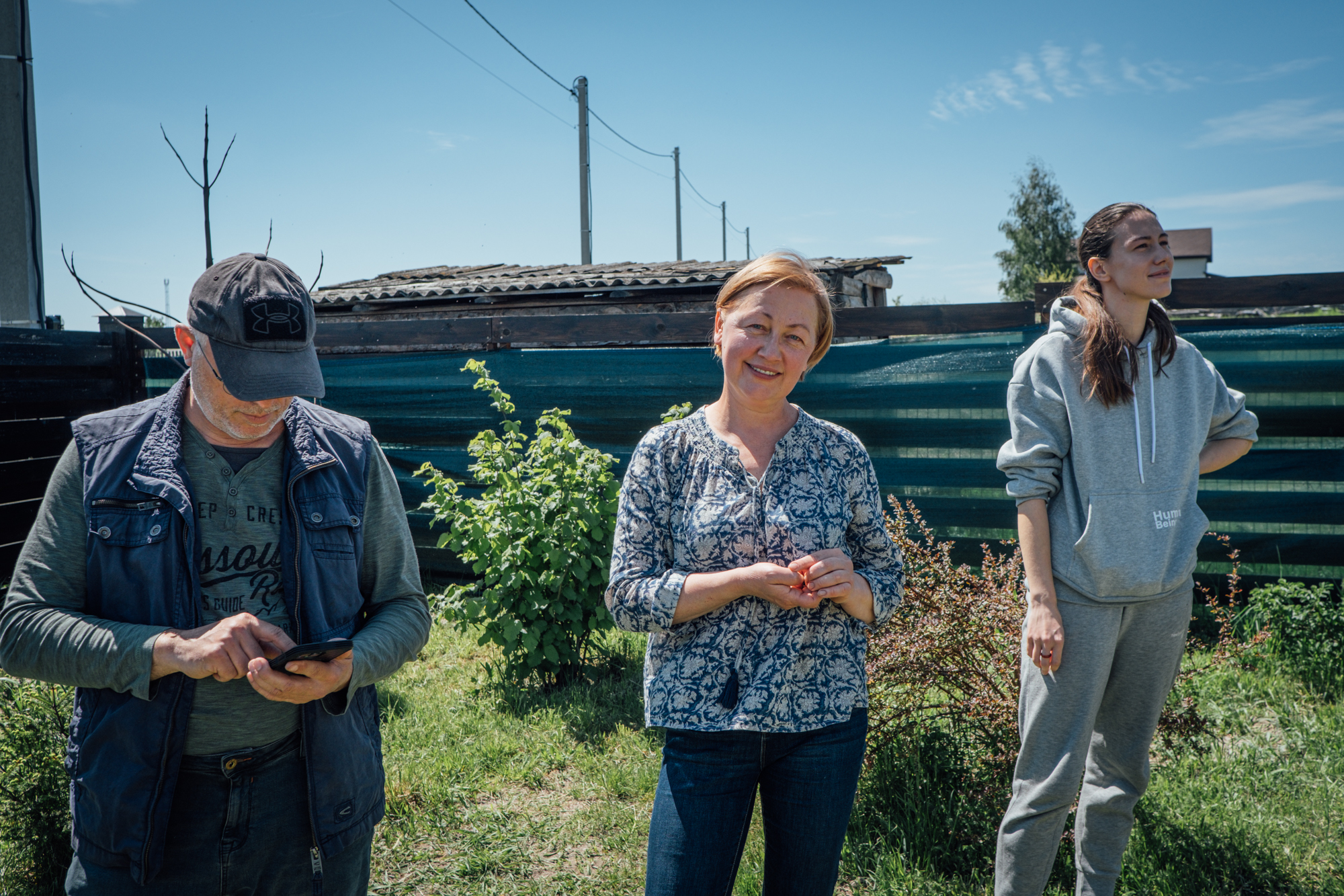 A photo of Vadym Smirnov (left) Alla Voloshynovych (centre) and Anastasia Smirnov (right) in their garden.