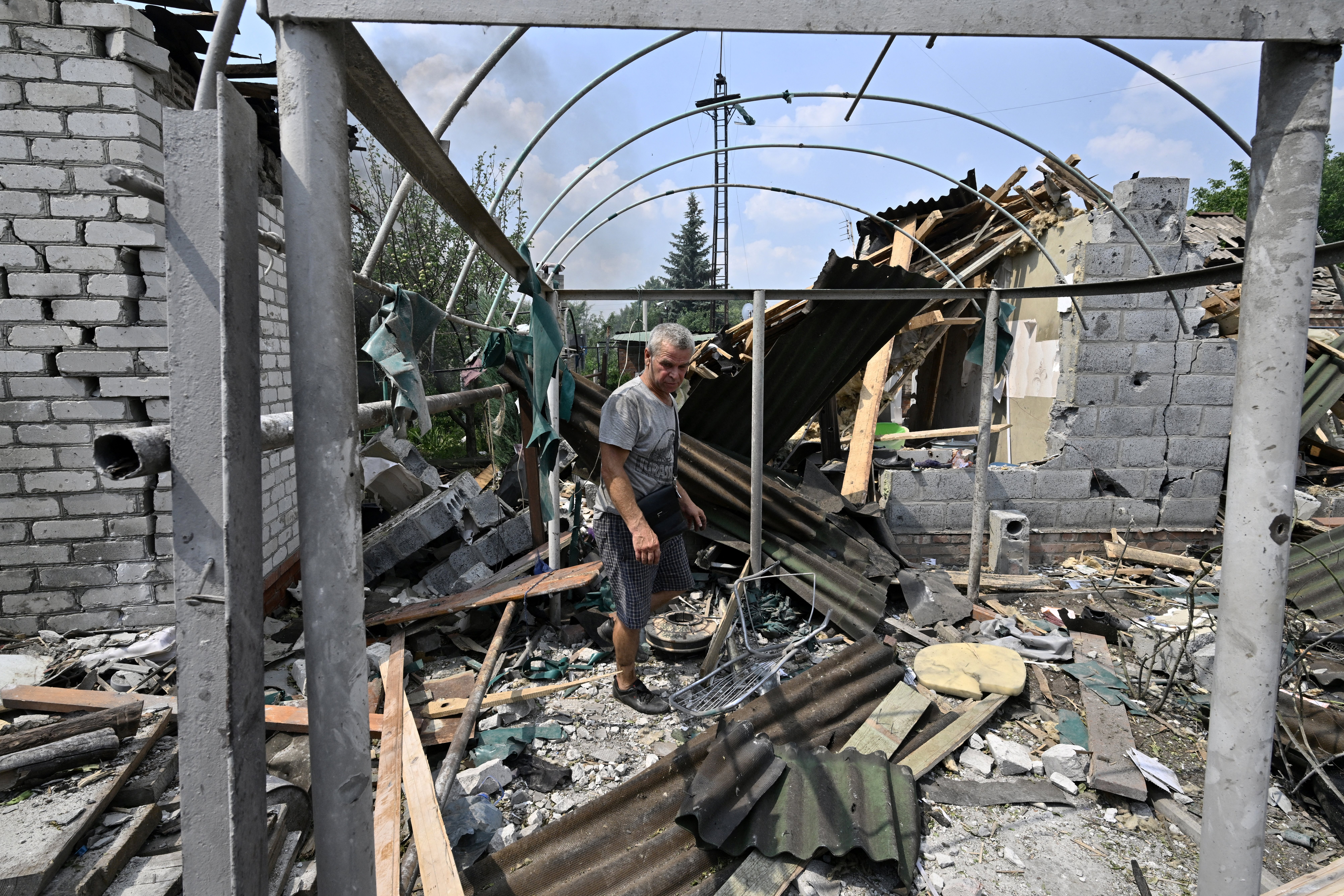 A resident walks among debris next to a destroyed house in Sloviansk, Ukraine.