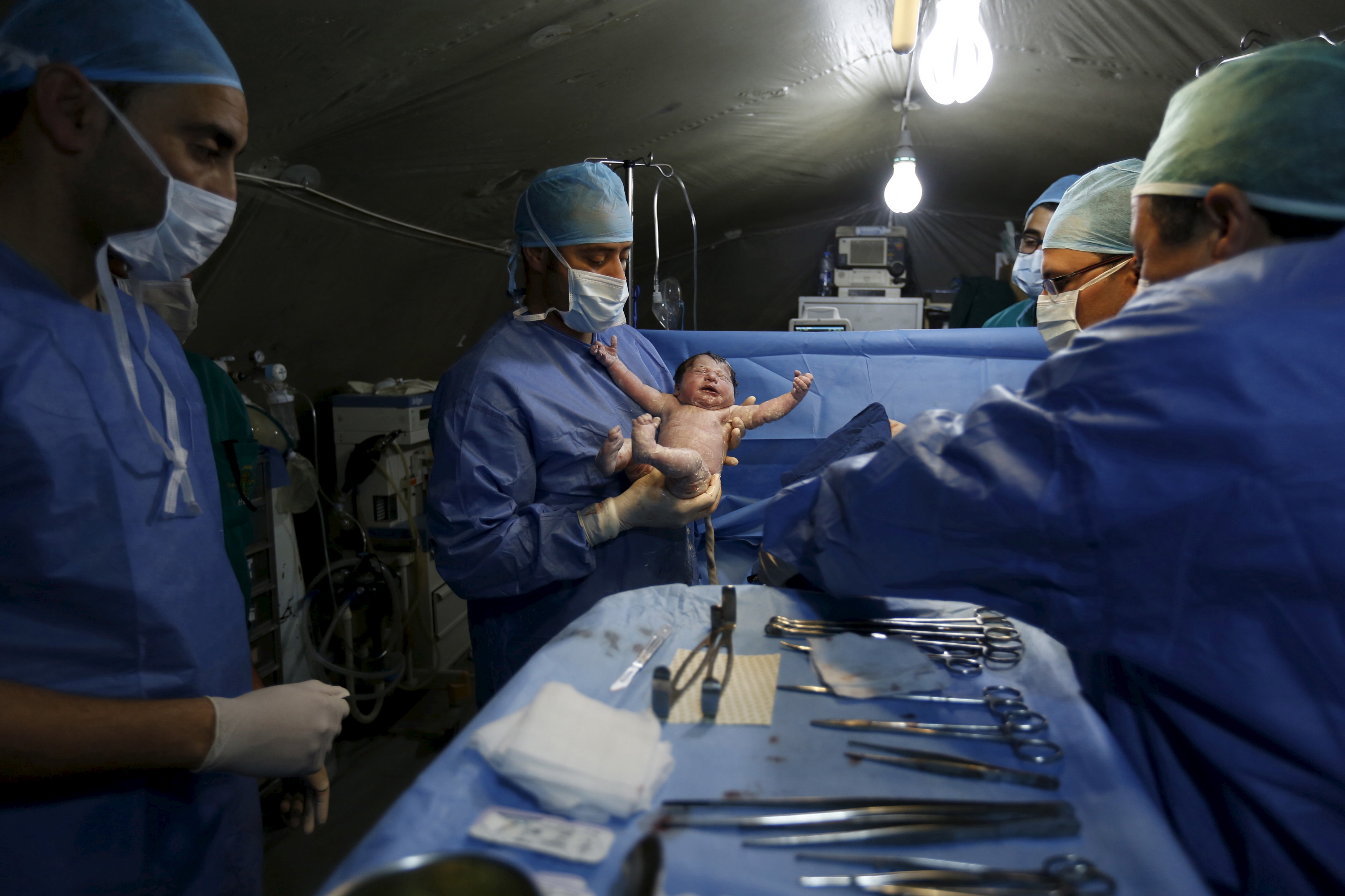 Moroccan doctors carry a Syrian baby Siwar, who was born by caesarean section in a field hospital in Al Zaatari refugee camp in Jordan