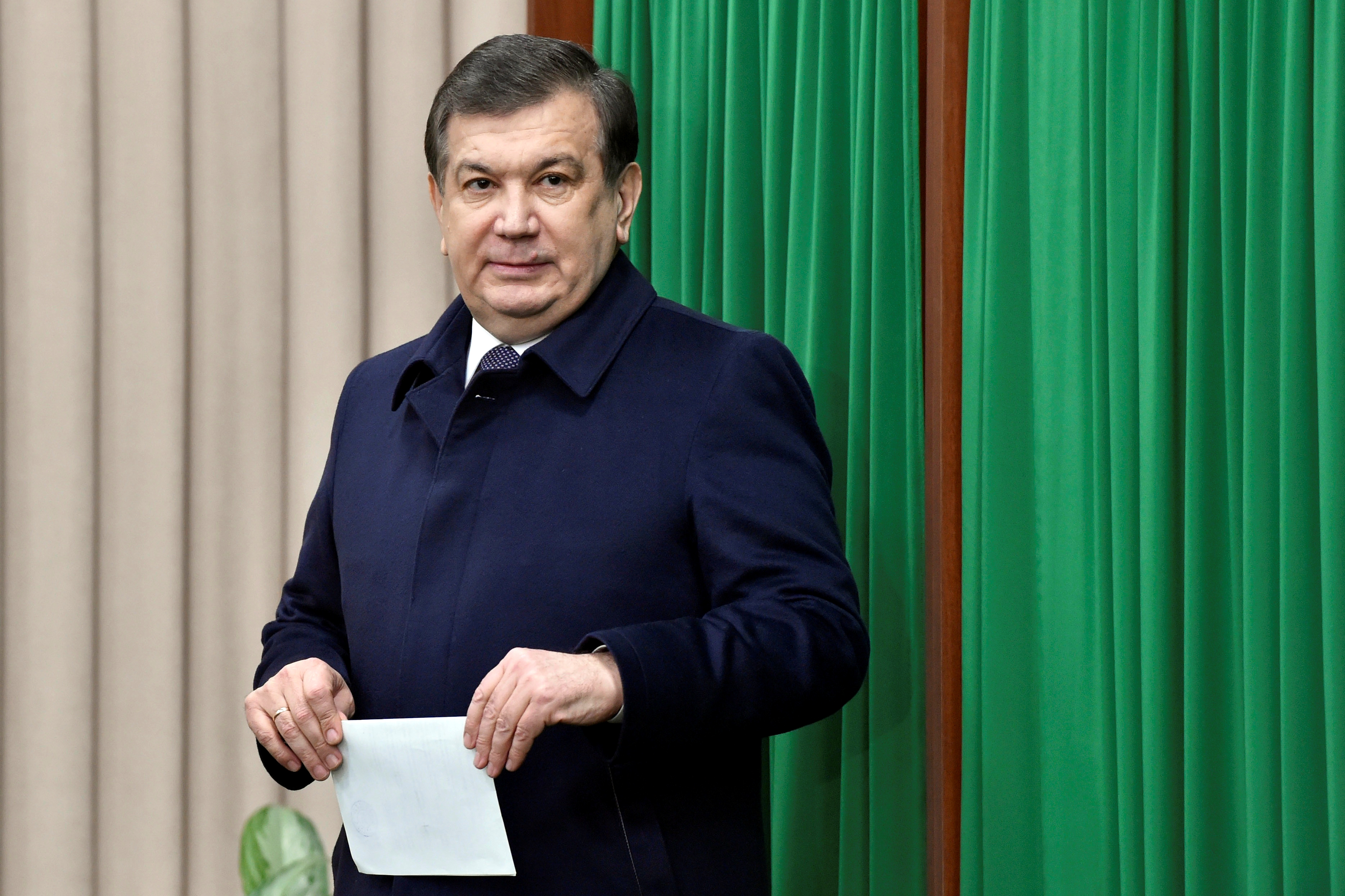 Uzbekistan's Prime Minister and interim President Shavkat Mirziyoyev leaves a voting booth at a polling station during a presidential election in Tashkent.