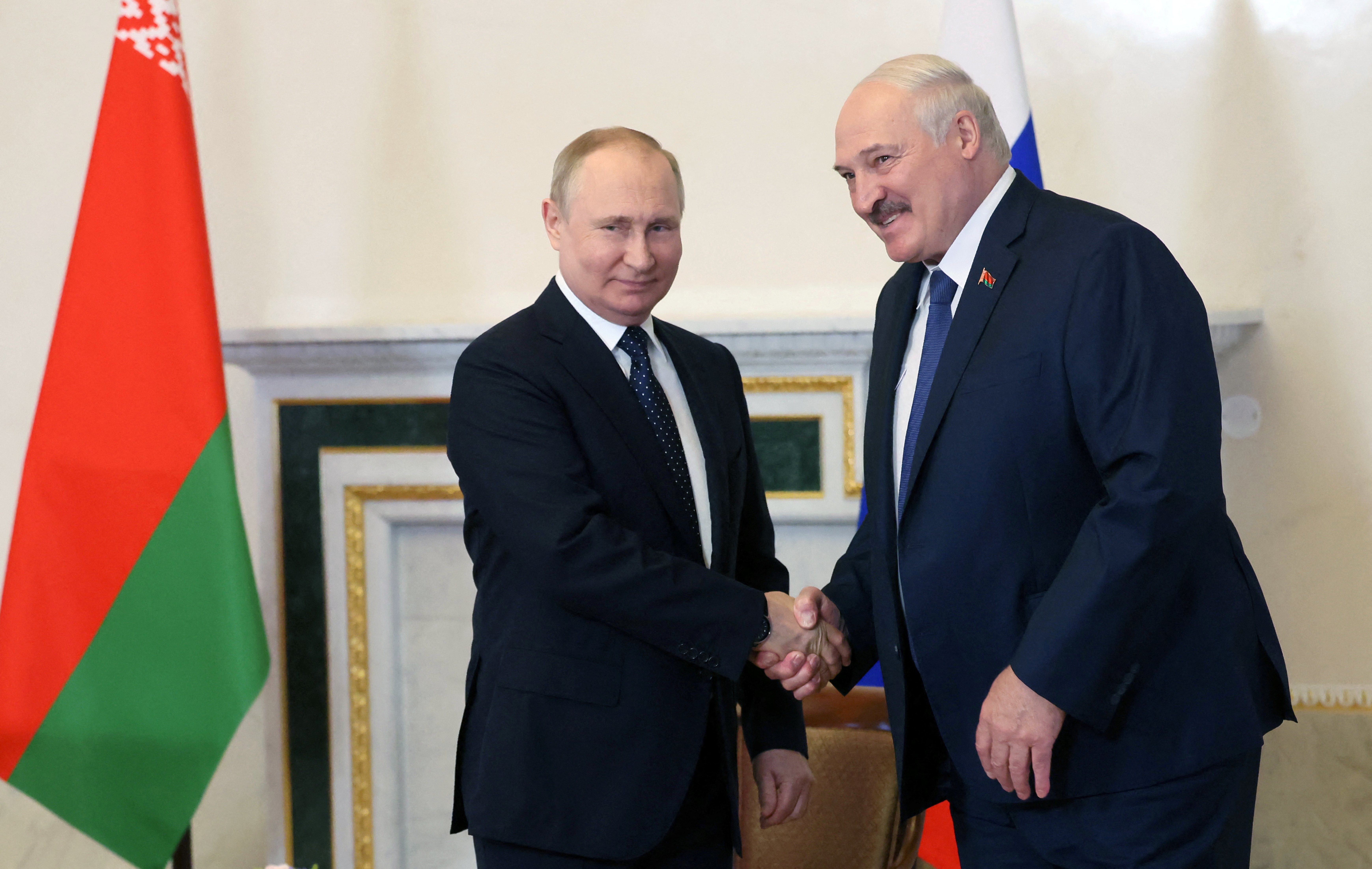 Russian President Vladimir Putin shakes hands with his Belarusian counterpart Alexander Lukashenko.