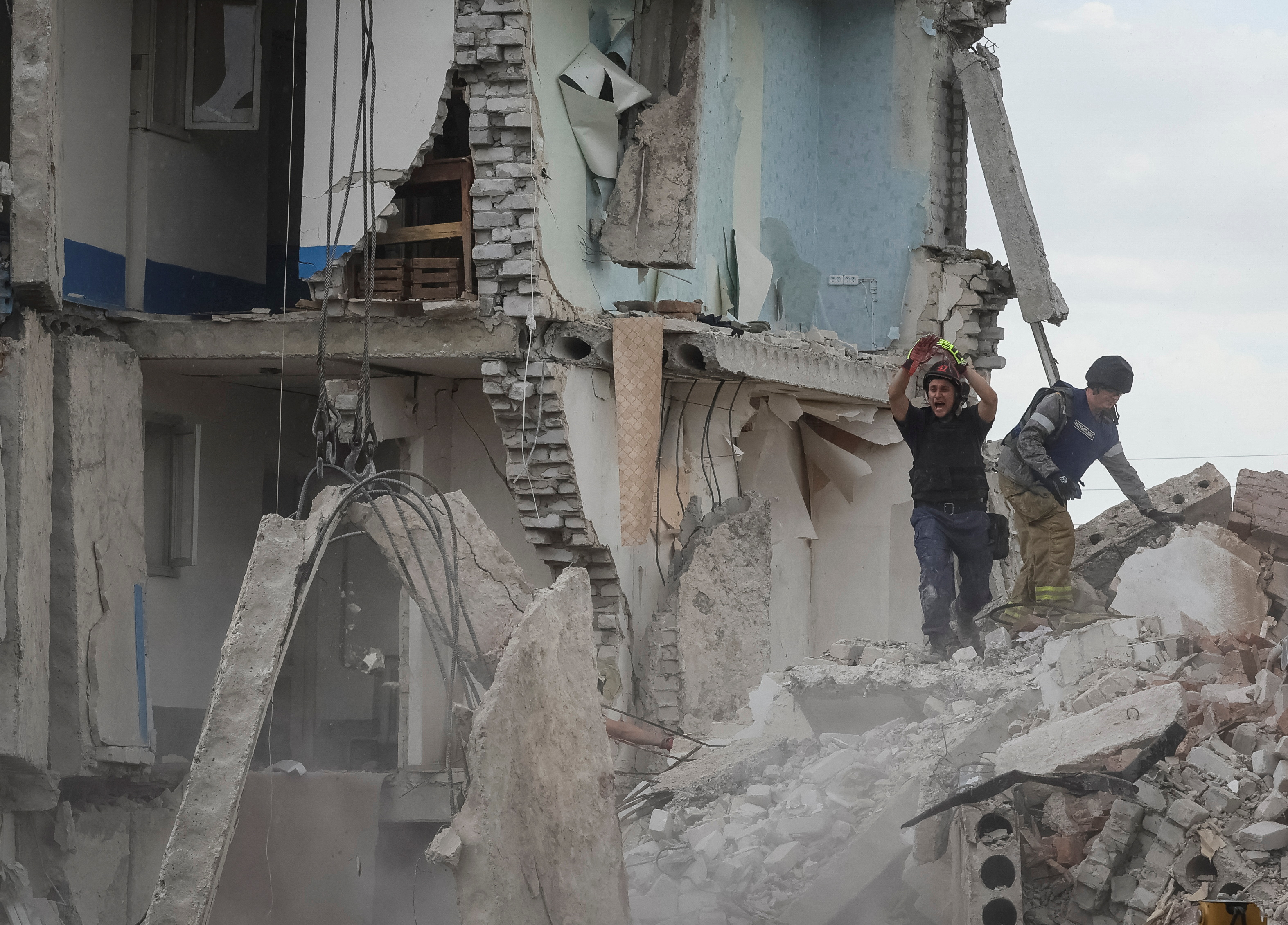 Rescuers work at a residential building damaged by a Russian military strike in the town of Chasiv Yar, Ukraine on July 10, 2022 [Gleb Garanich/Reuters]