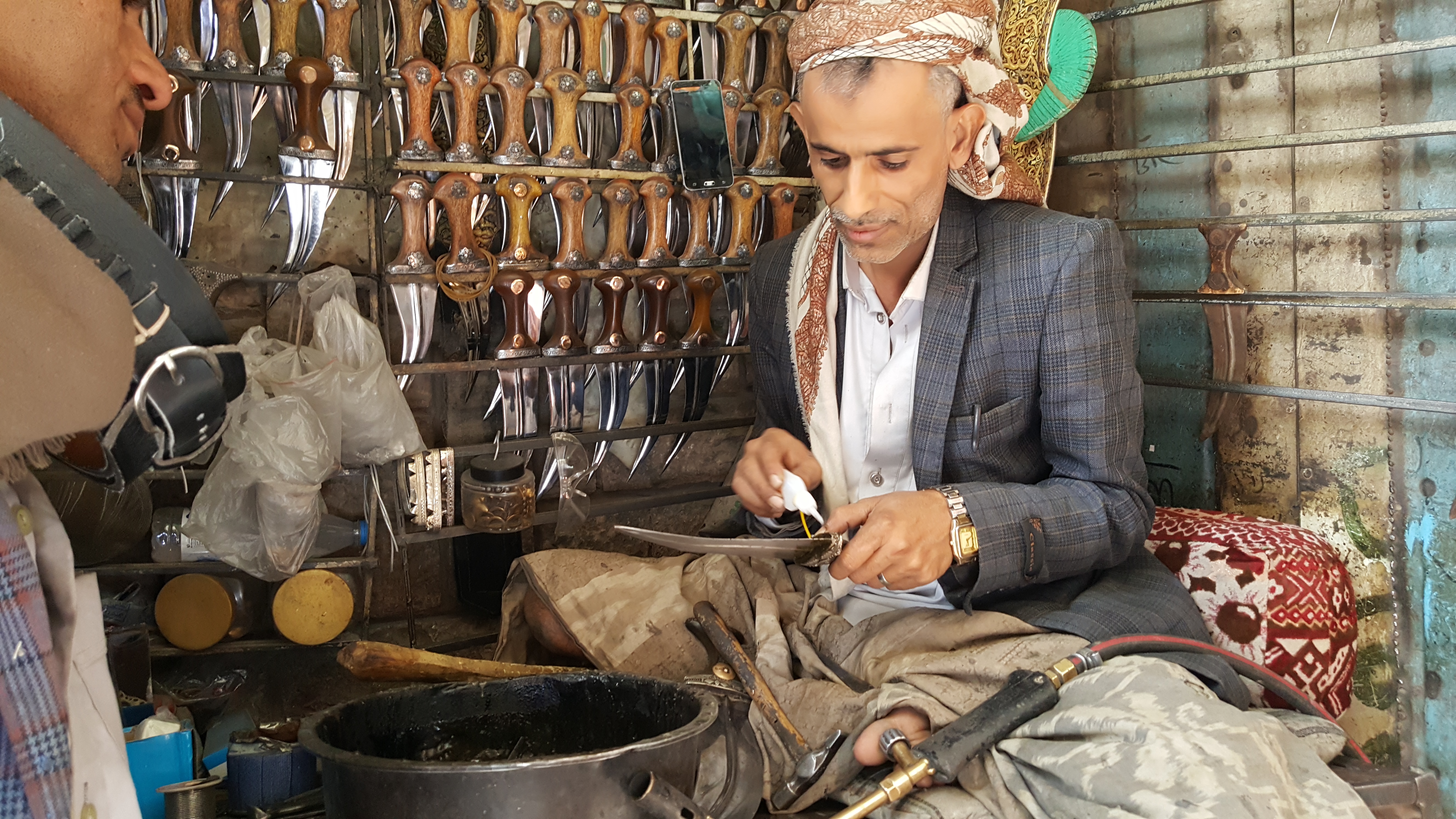 A man in a shop selling traditional Yemeni daggers, jambiyas