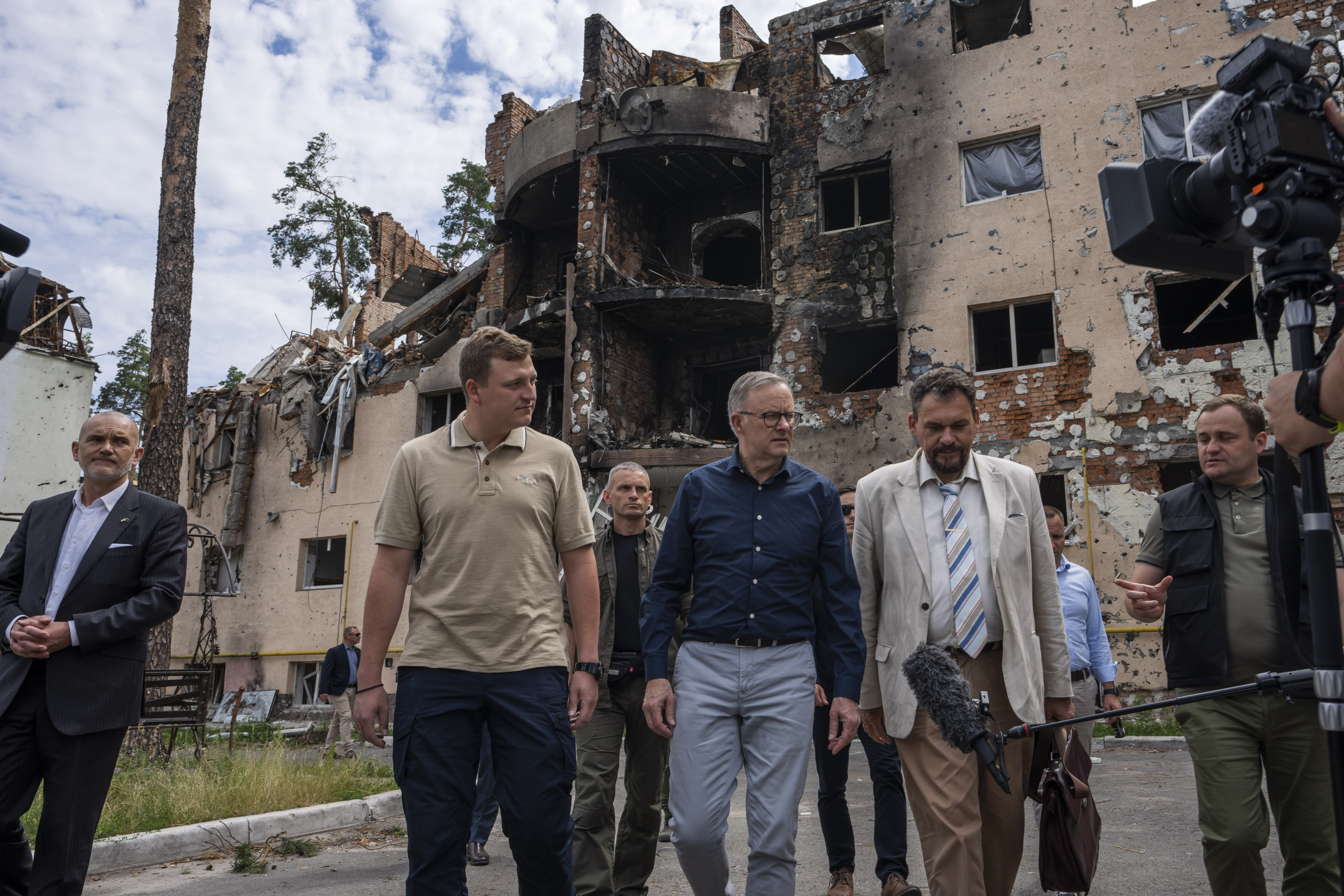 Australian Prime Minister Anthony Albanese, center, listens to a translator, during his visit to Irpin, on the outskirts of Kyiv