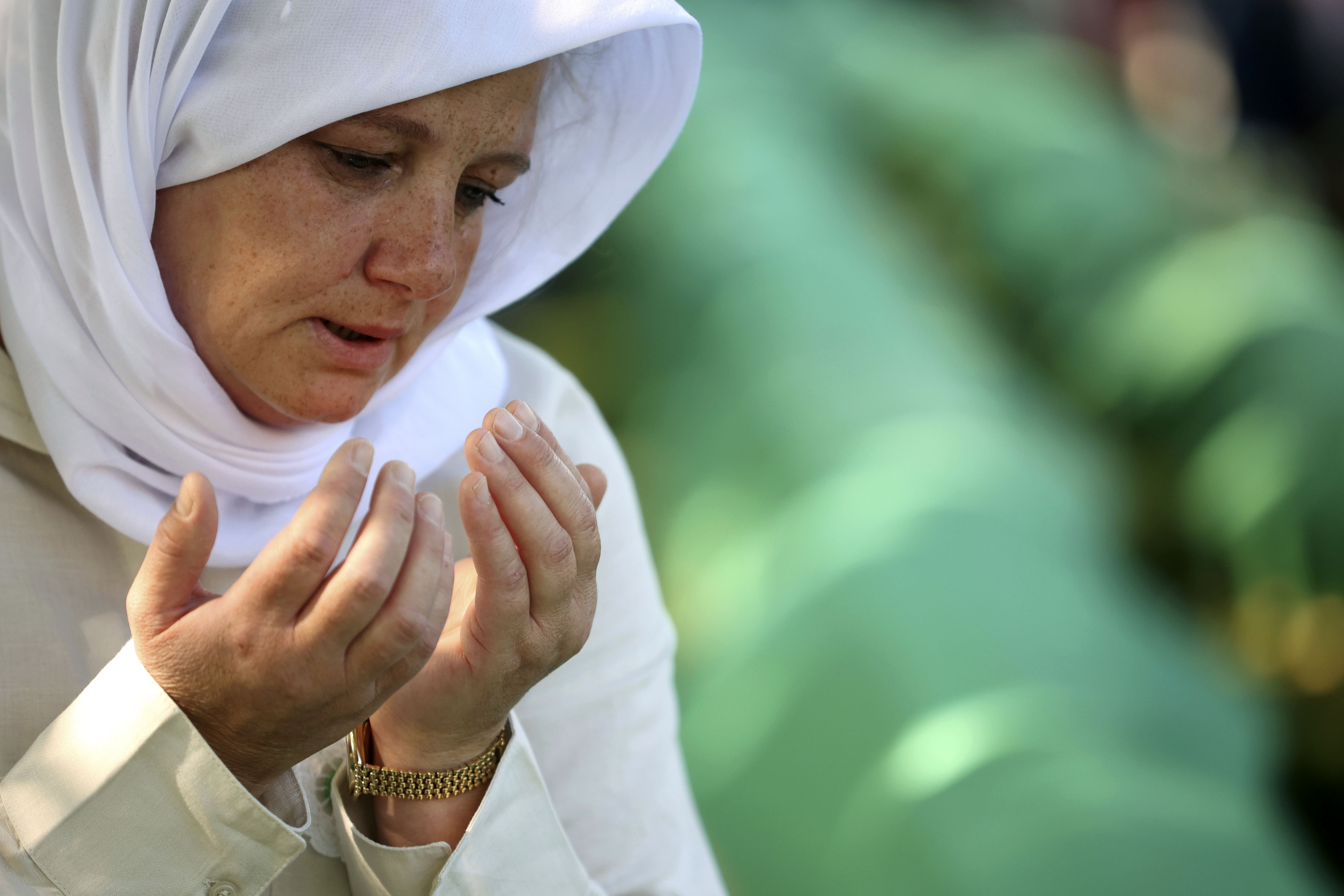 Bosnian muslim woman mourns next to the coffin