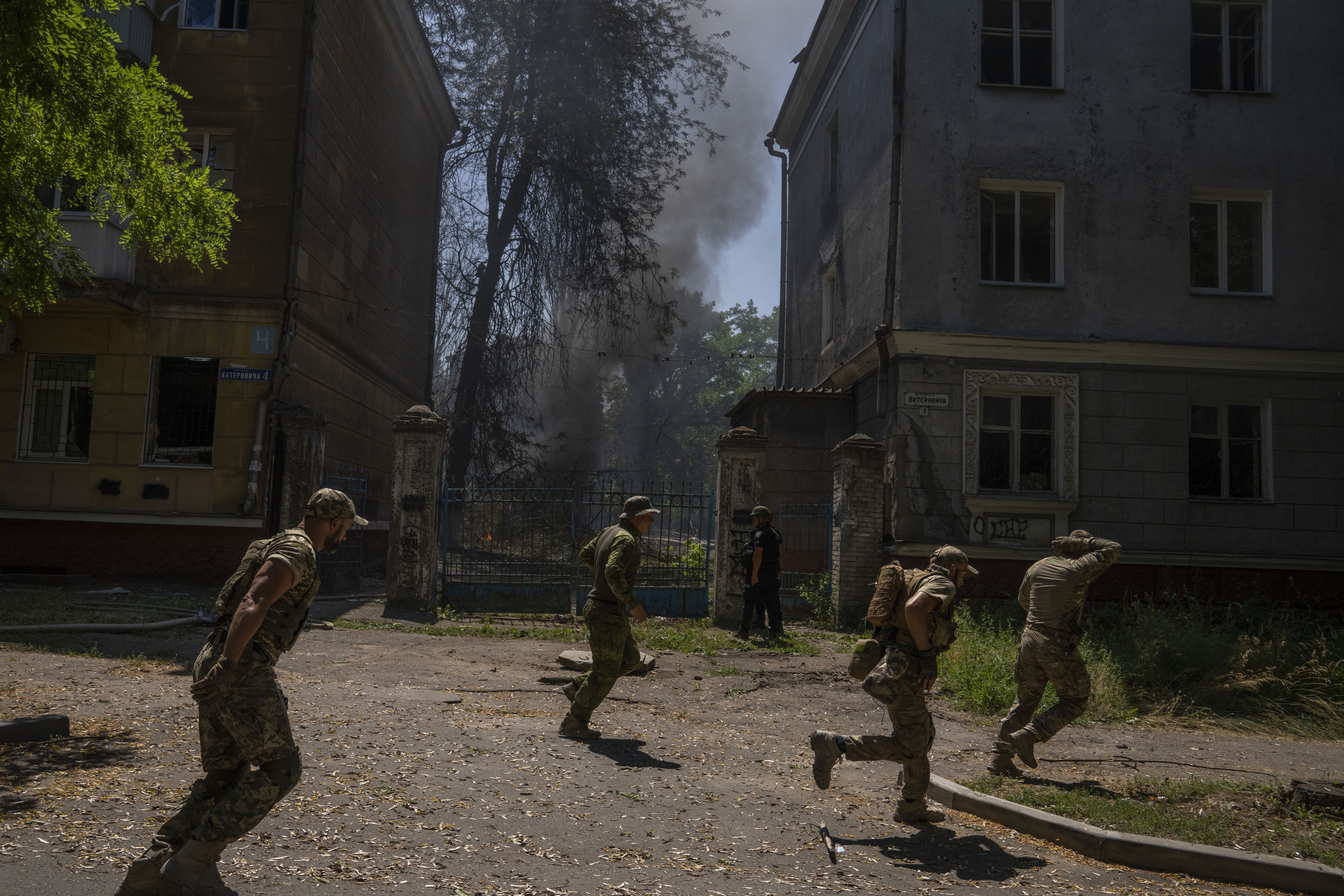 Ukrainian soldiers run after a missile strike hit a residential area, in Kramatorsk