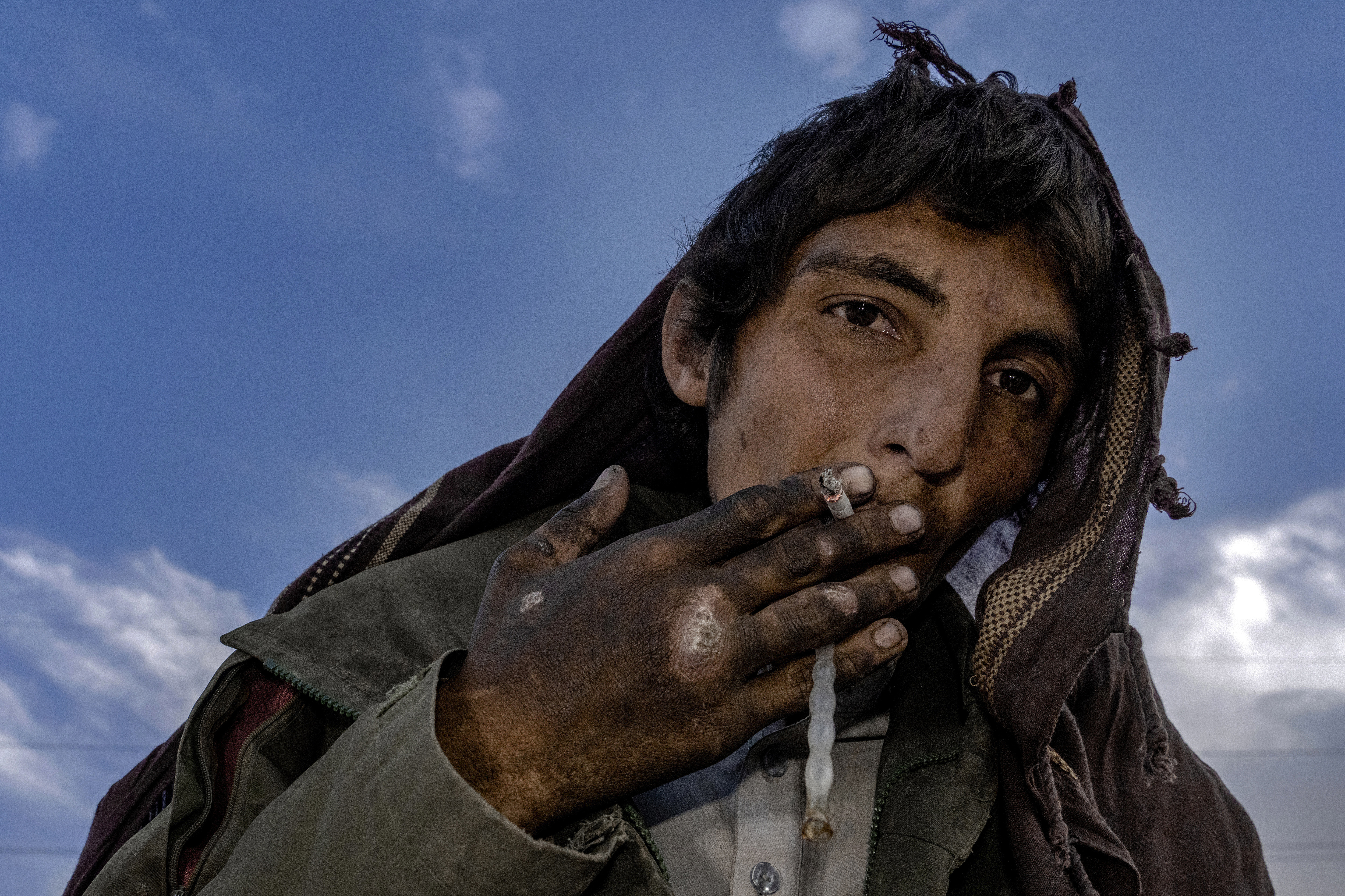 An Afghan drug addict smokes heroin