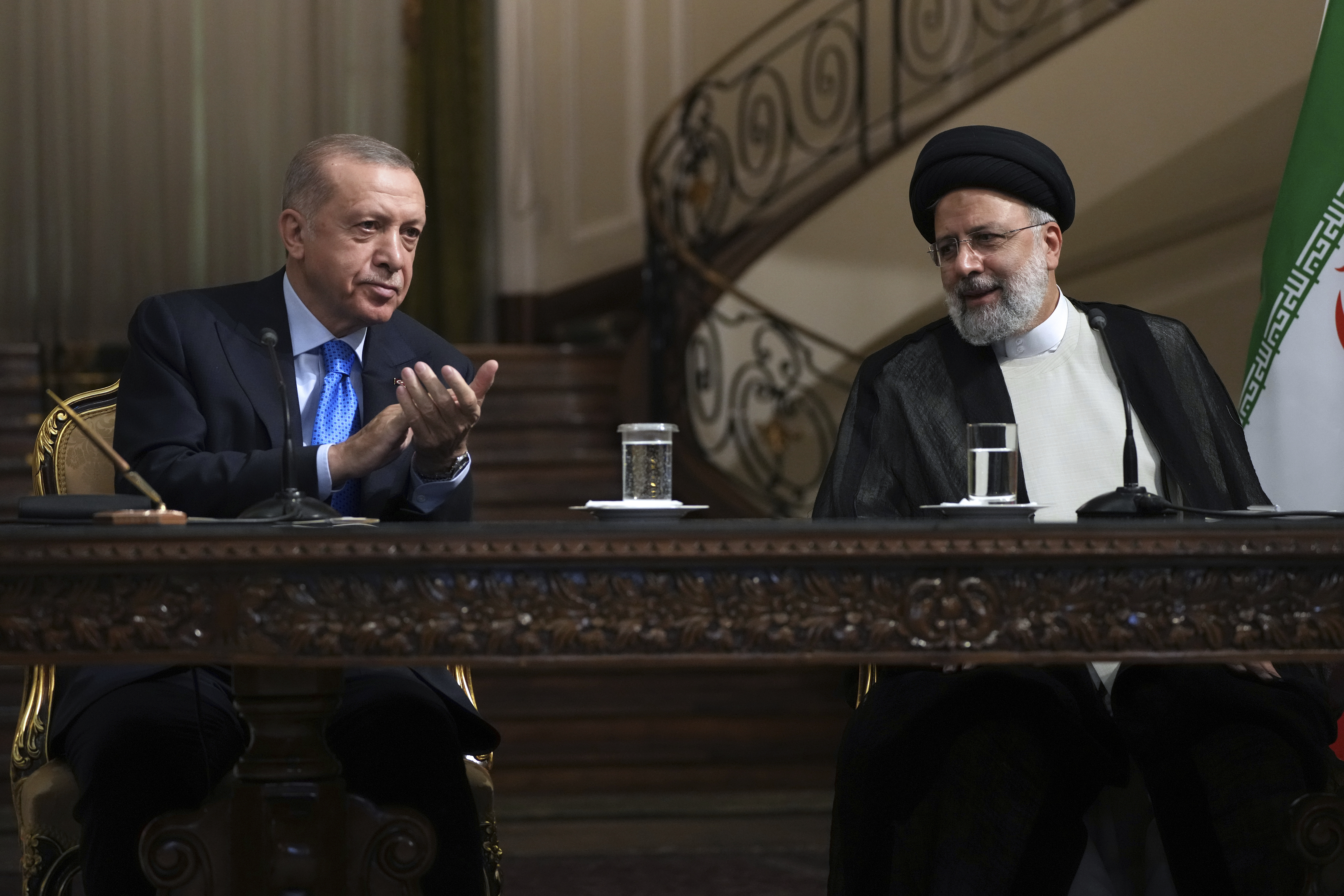 Turkish President Recep Tayyip Erdogan claps as Iranian President Ebrahim Raisi concludes his speech during their joint press briefing at the Saadabad Palace, in Tehran.