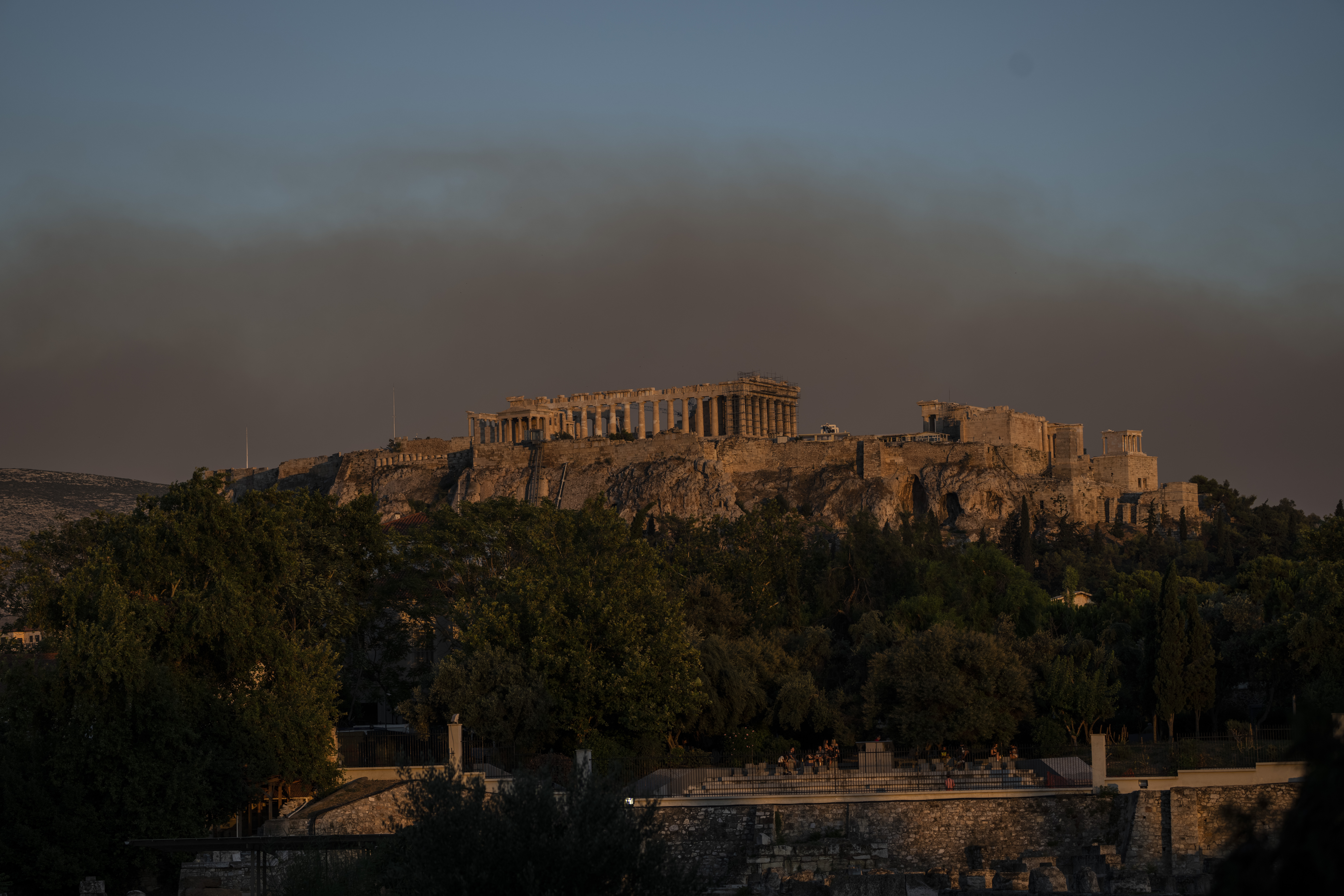 Smoke from a fire blanketed part of the Athenian sky as it is seen behind the ancient Acropolis hill with the Parthenon temple