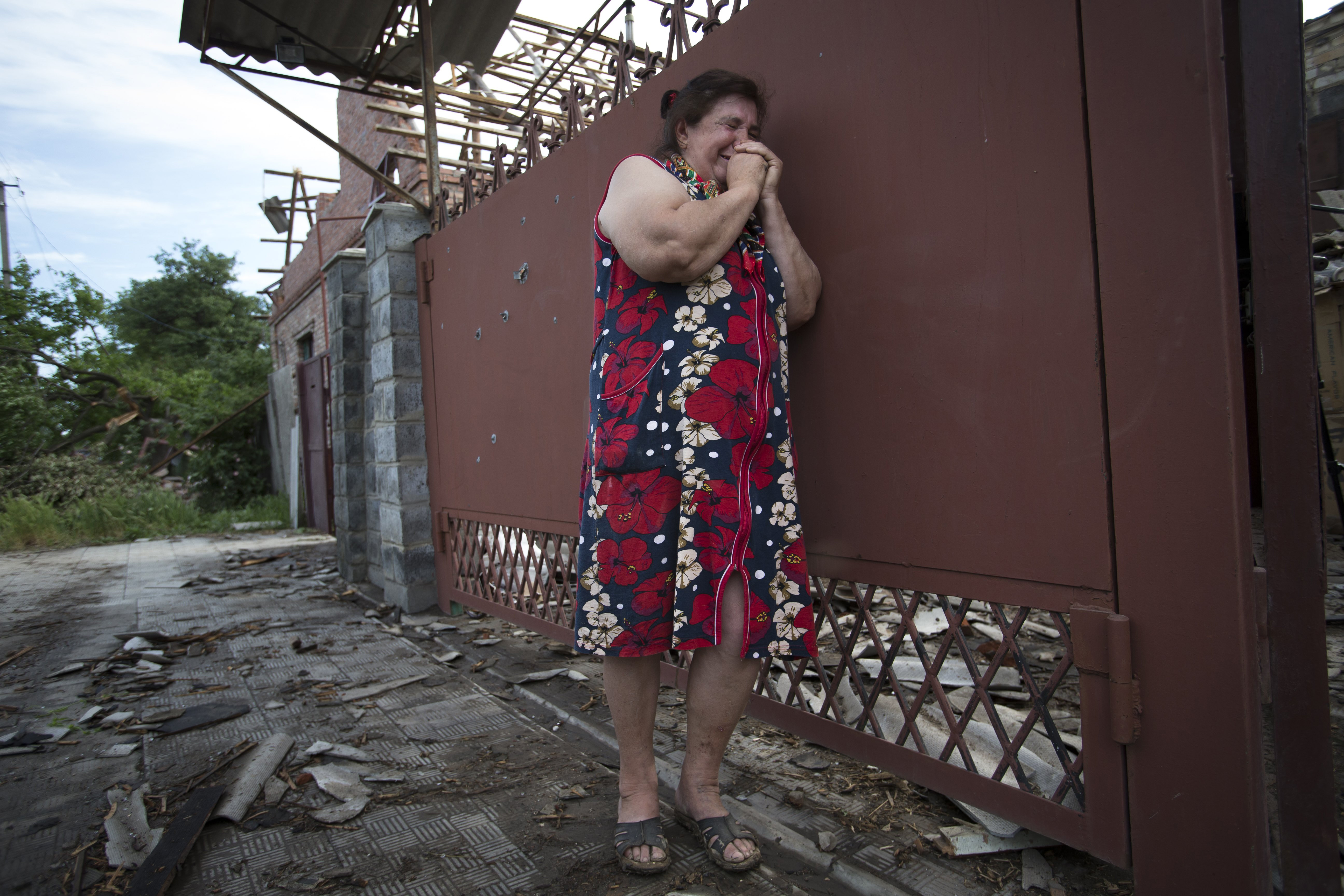 Yekaterina Len, 61, cries outside her ruined house following a shelling in Slovyansk, eastern Ukraine, Tuesday, May 20, 2014