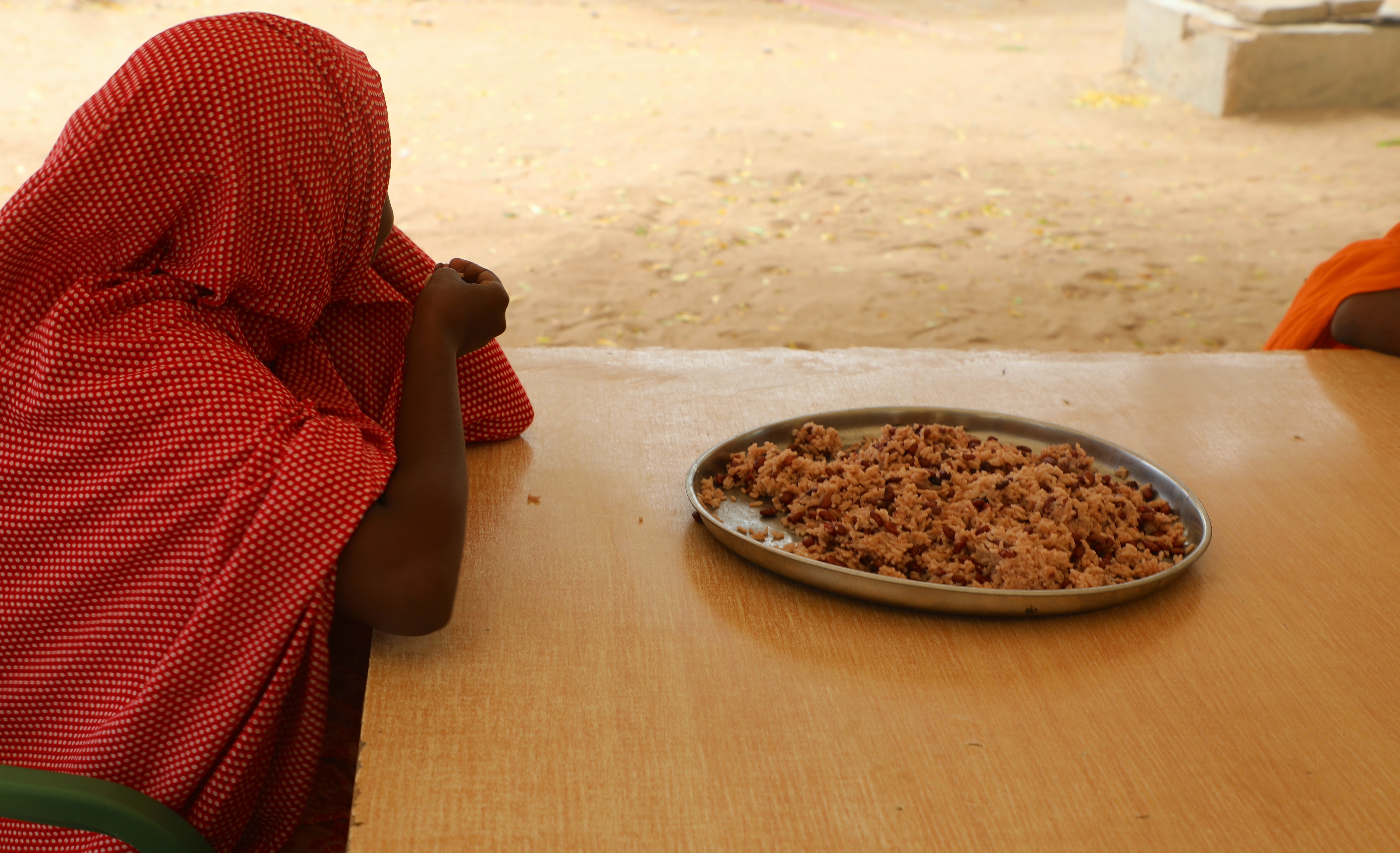 On June 7, 2022, Amira, 12 years, enjoys her meal at a Children’s center.