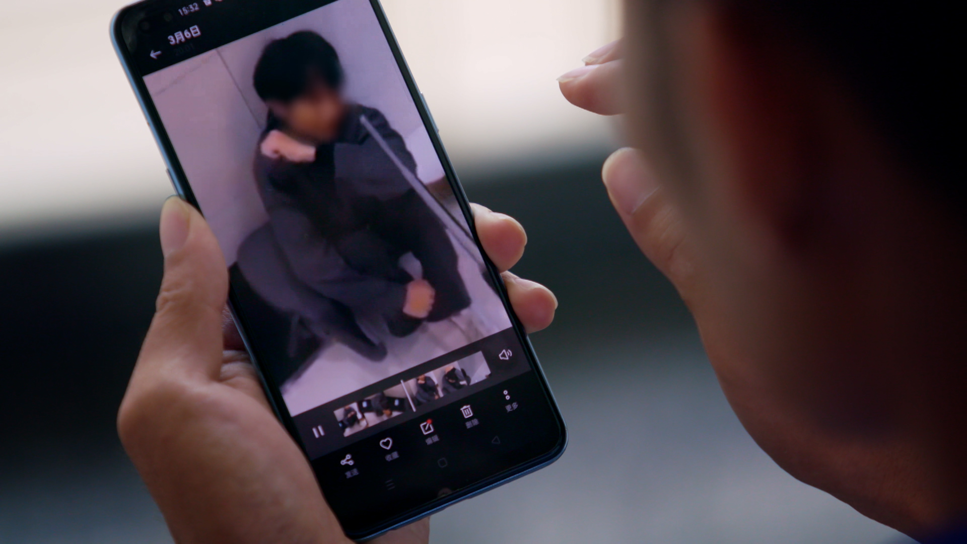 A person watches a video on a mobile phone