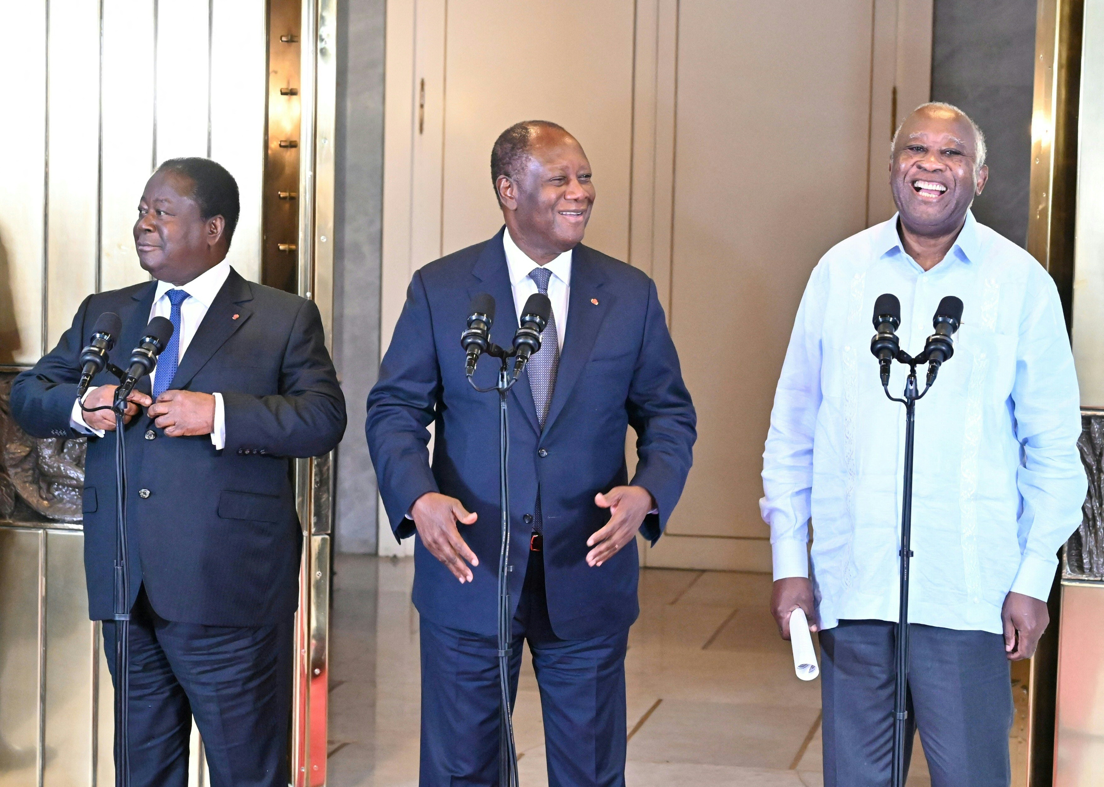 Ivory Coast President Alassane Ouattara (C) stands next to his predecessors Henri Konan Bedie (L) and Laurent Gbagbo (R) after a meeting at the presidential palace in Abidjan on July 14, 2022.