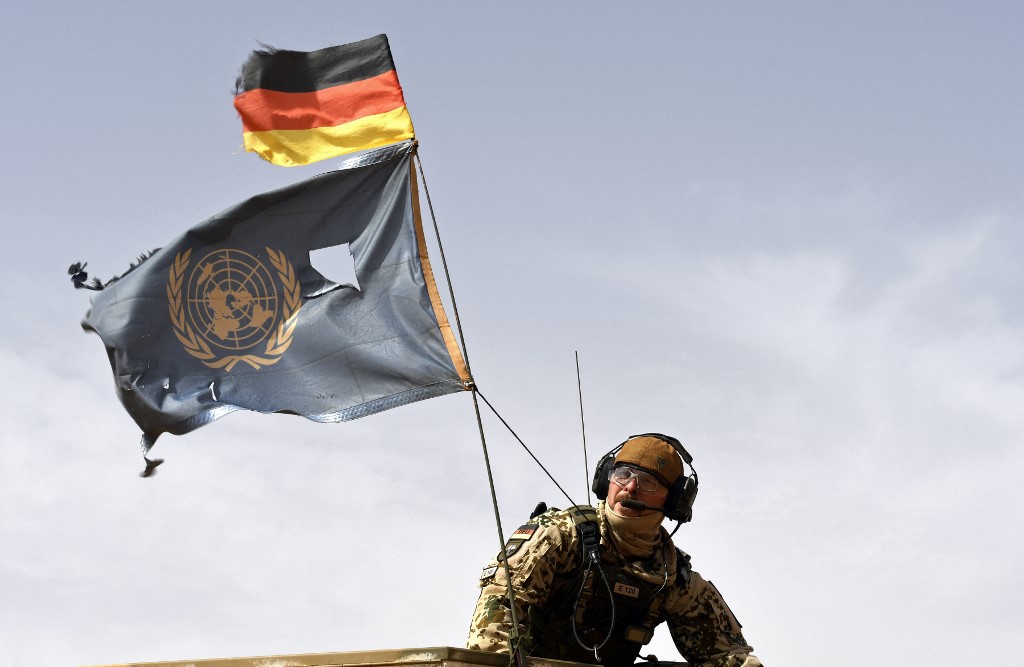 a German soldier in Mali with German and UN flags