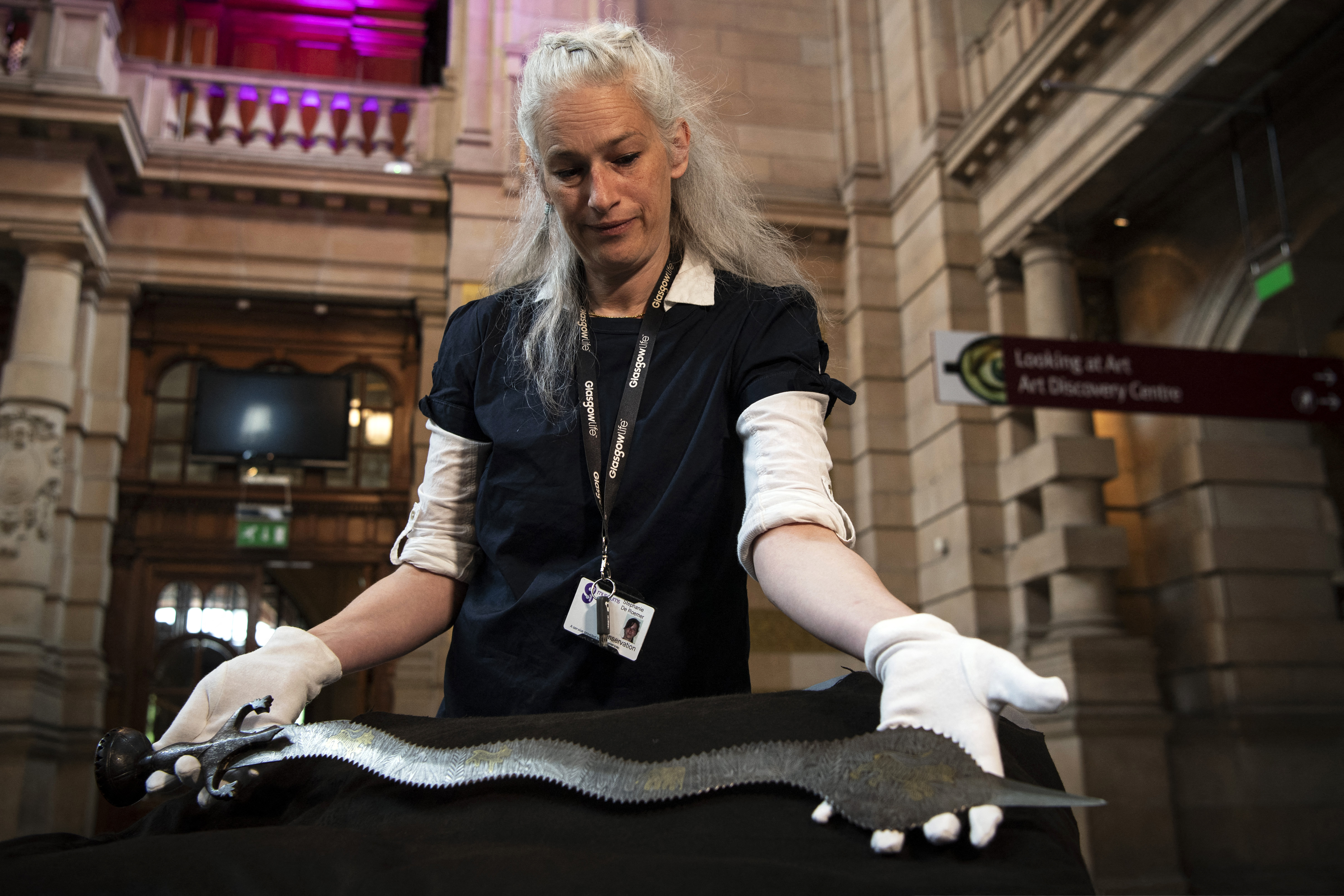 Museum conservator Stephanie De Roemer holds a ceremonial Indo-Persian sword