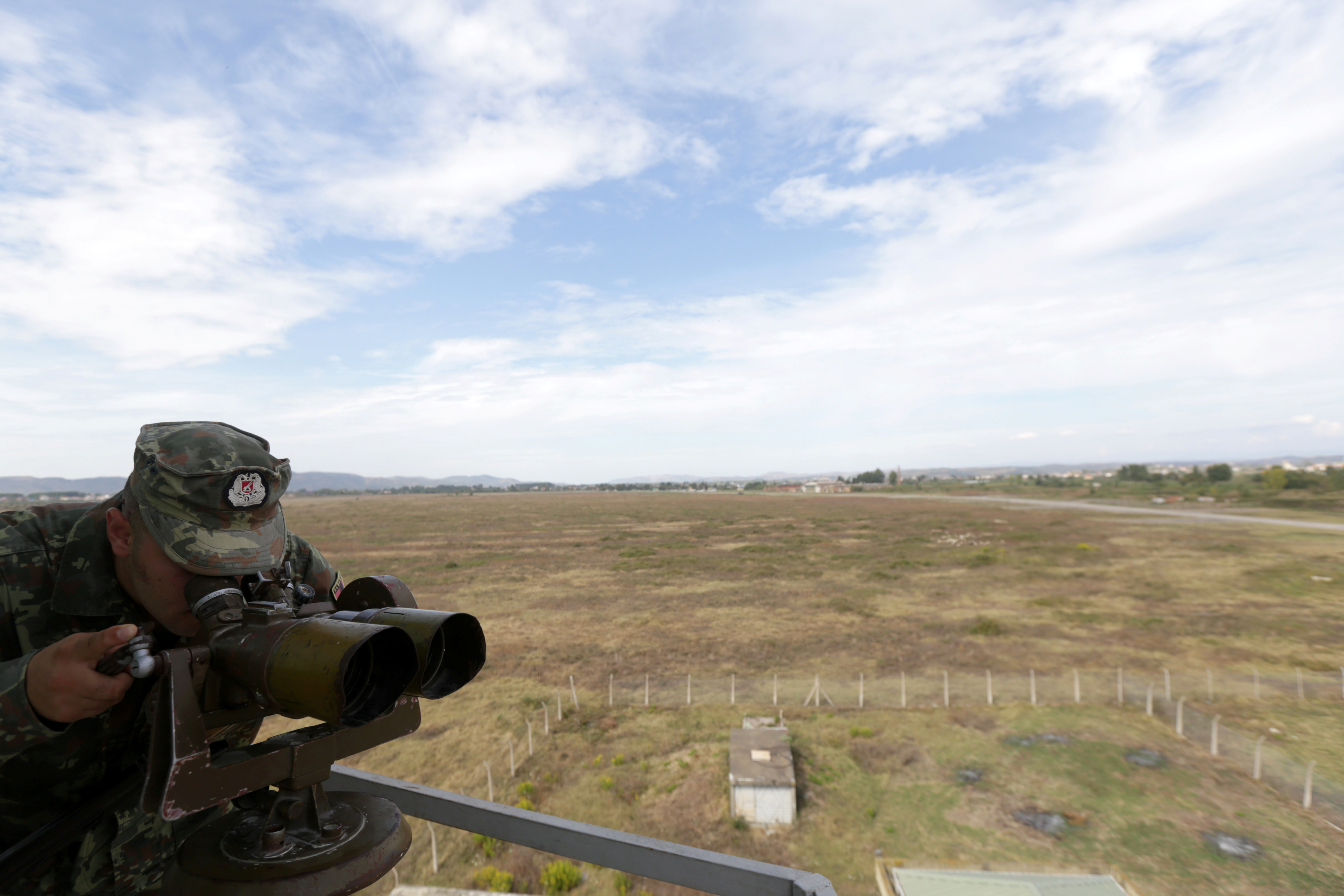 An Albanian soldier monitors the area around the Kucova airbase in Kucova