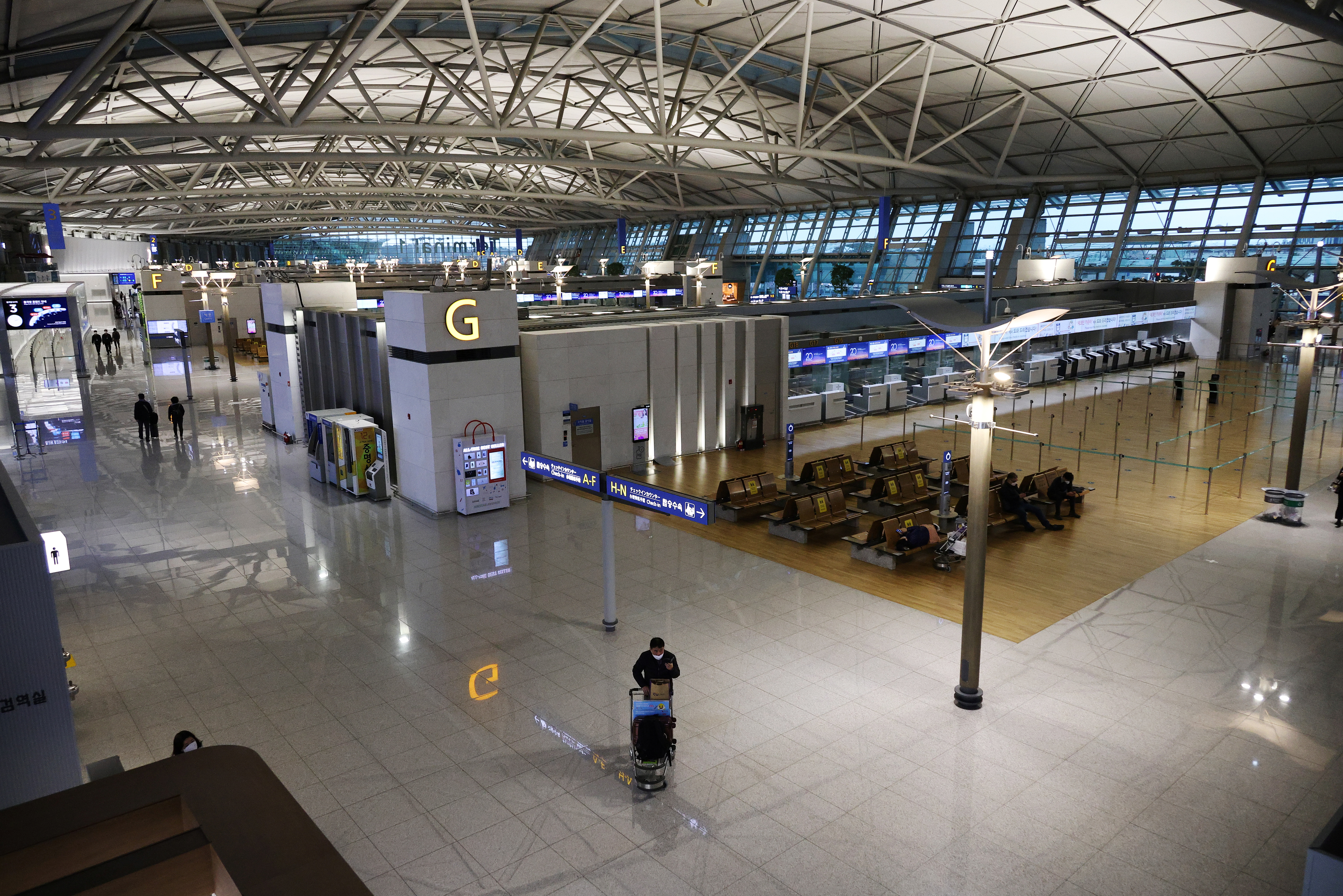 A man wearing a mask stands in the Incheon International Airport in Incheon, South Korea.