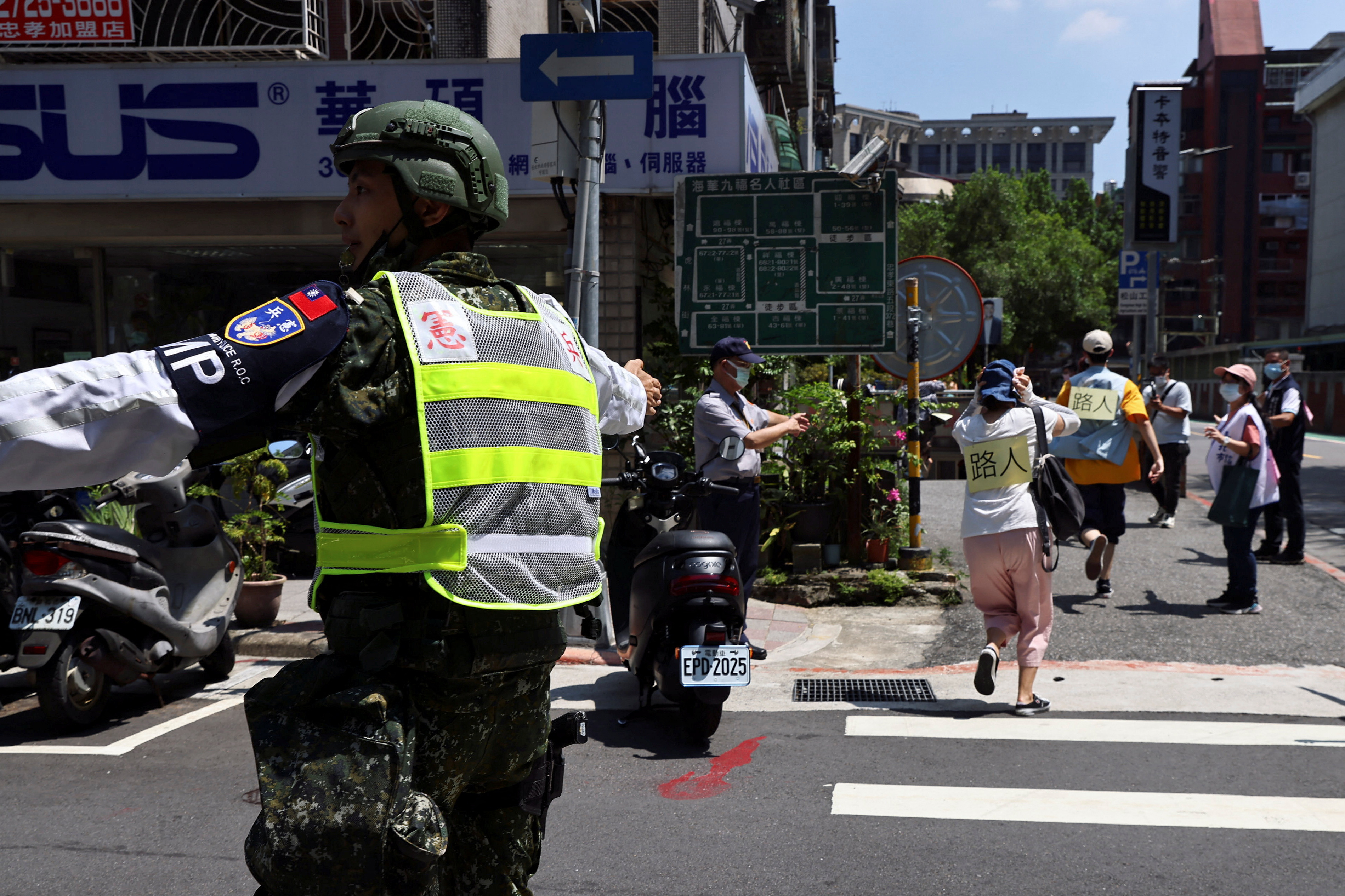 A military police officer guides people to evacuate to an underground space