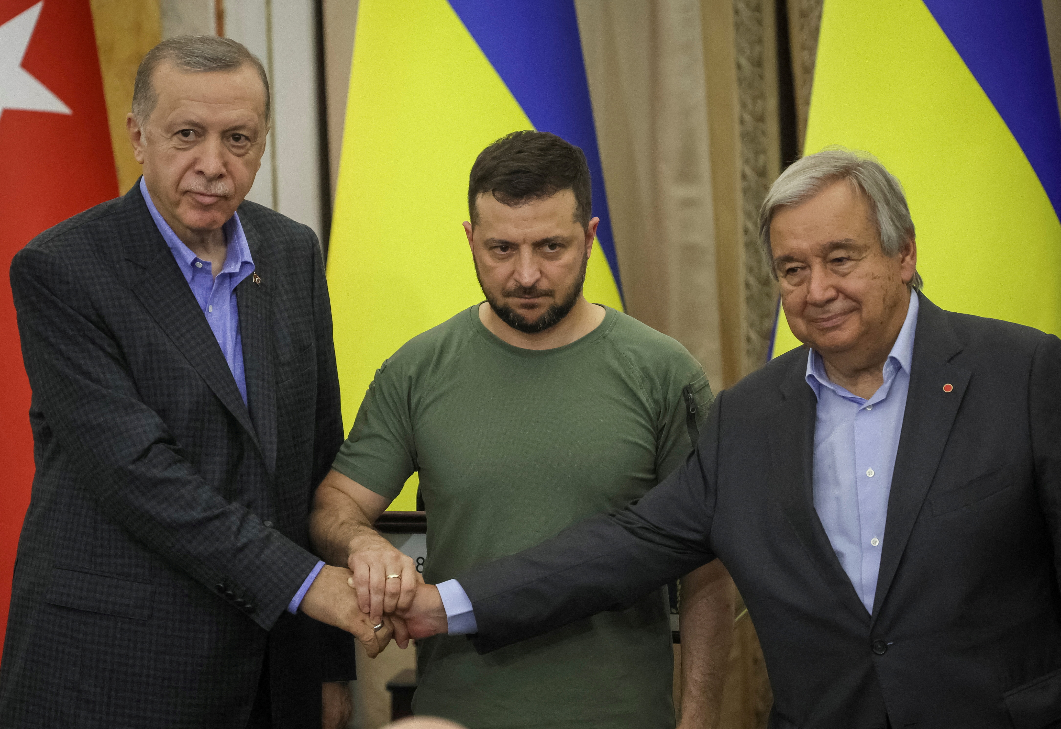 Ukrainian President Volodymyr Zelenskiy, Turkish President Tayyip Erdogan and UN Secretary-General Antonio Guterres shake hands after a joint news conference