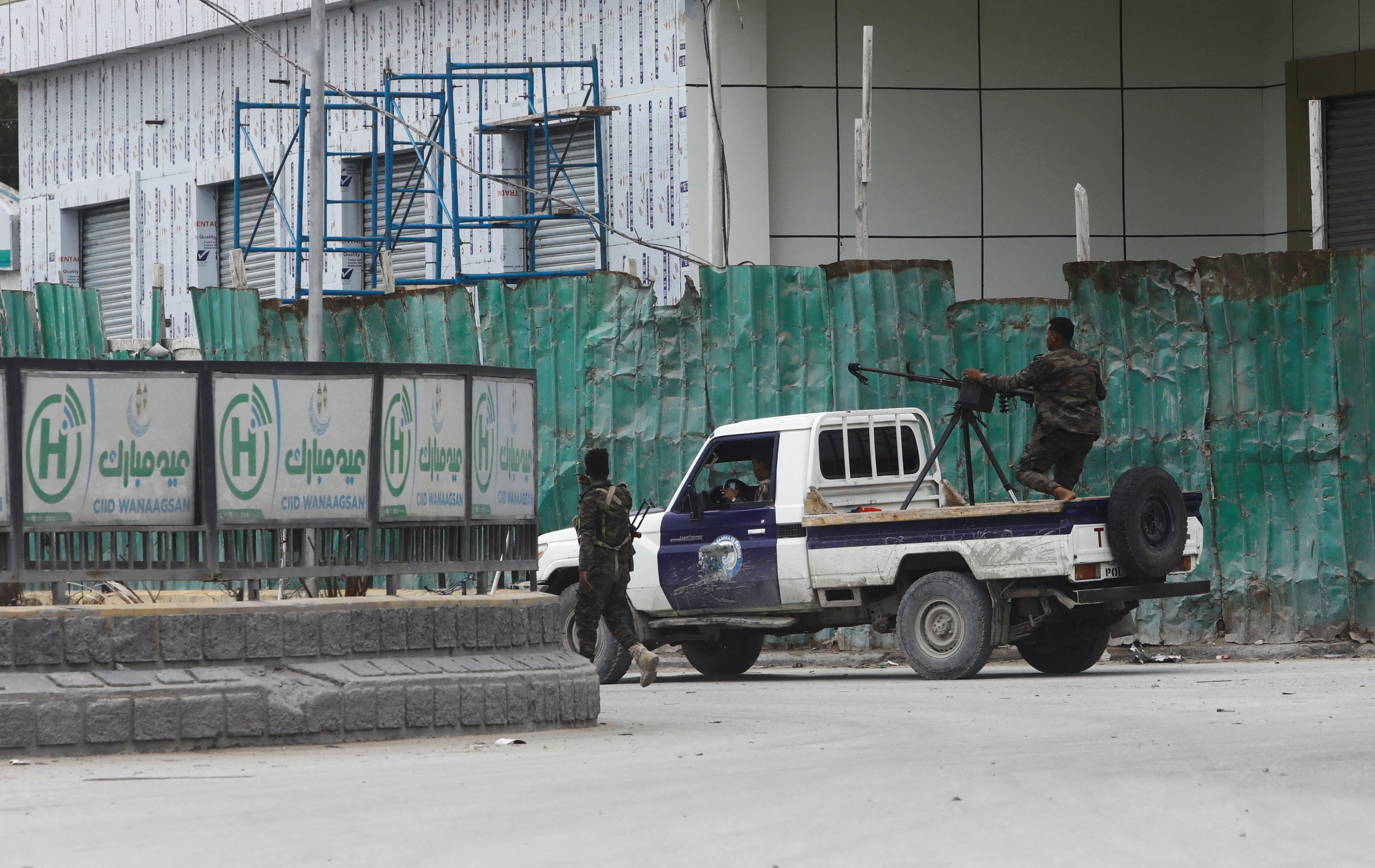Somali police officers ride on their pick-up truck towards Hotel Hayat.