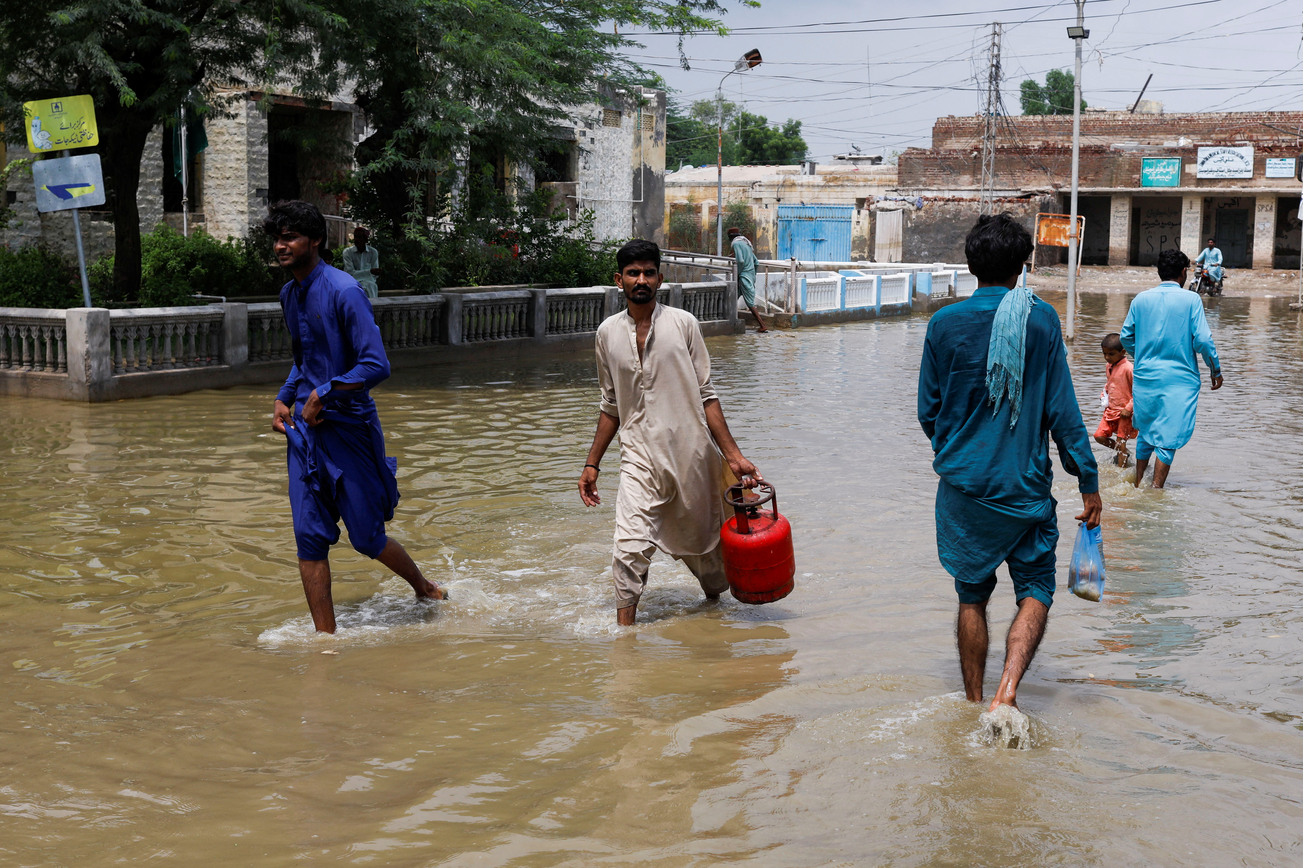Men walk through a flooded street in Jacobabad, Pakistan.