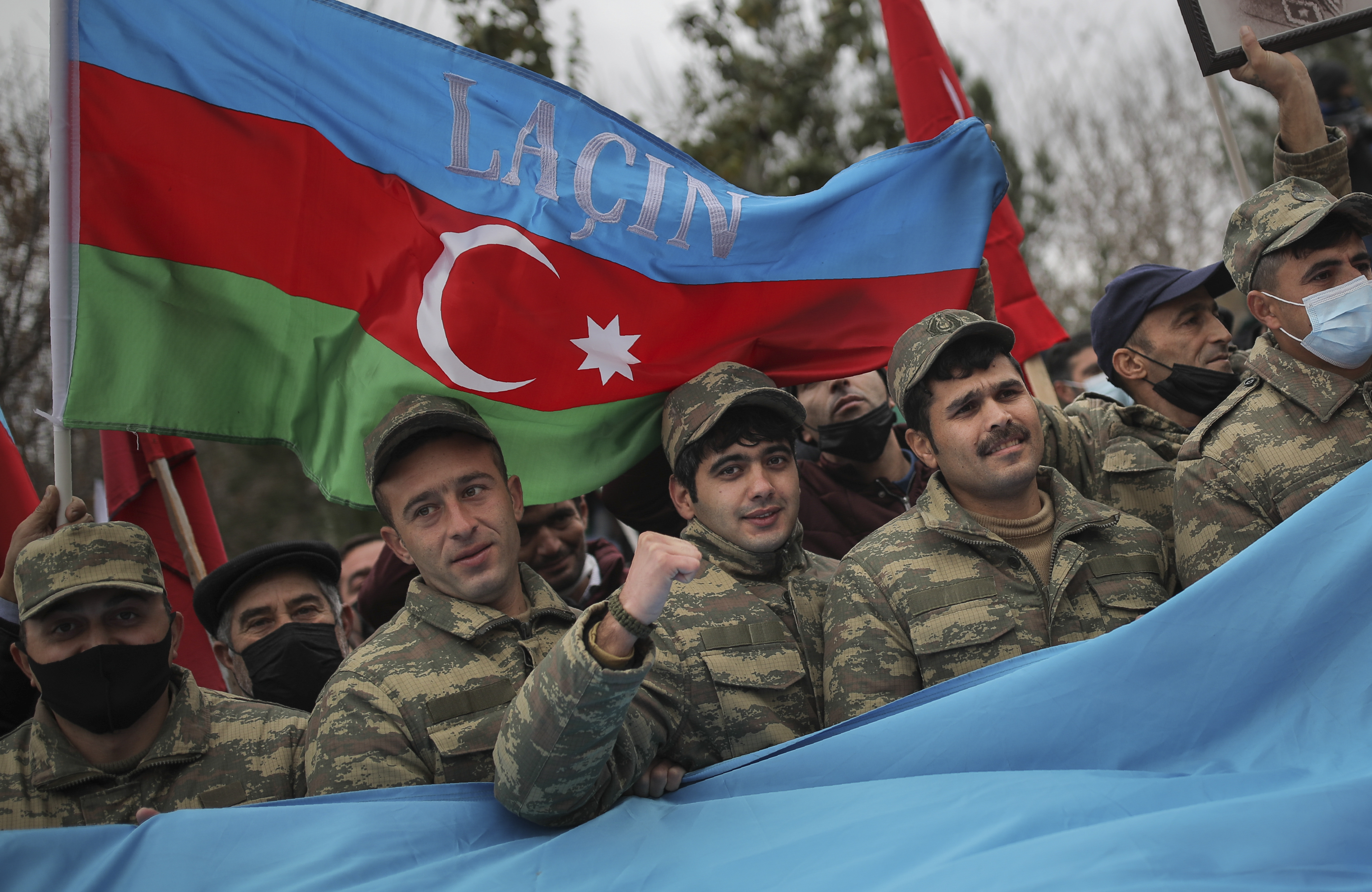 Azerbaijani soldiers with a national flag with the words "Lachin" celebrate the transfer of the Lachin region to Azerbaijan's control,