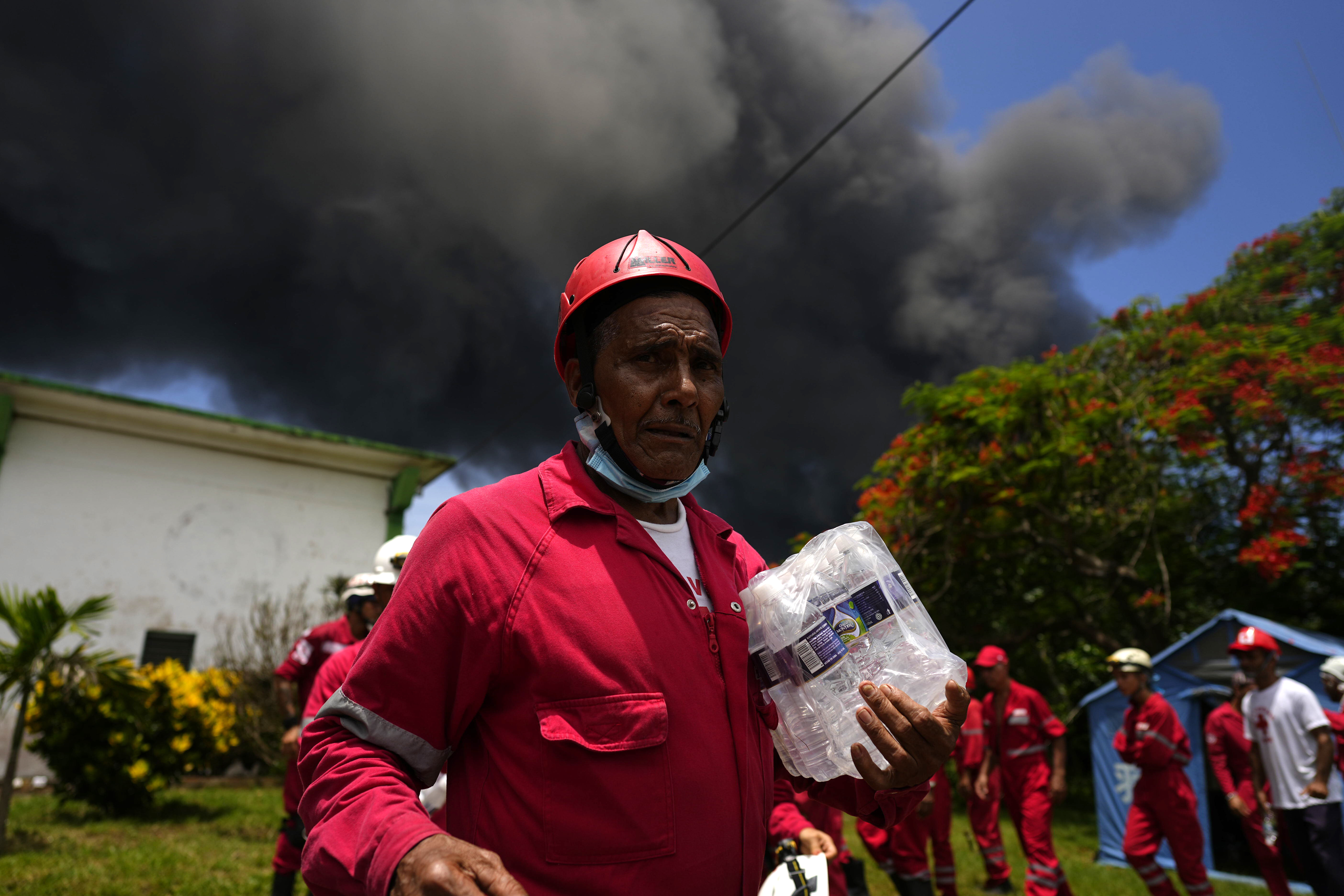 Members of the Cuban Red Cross prepare to be transported to the Matanzas Supertanker Base, where firefighters work to quell a blaze which began during a thunderstorm the night before, in Matazanas, Cuba