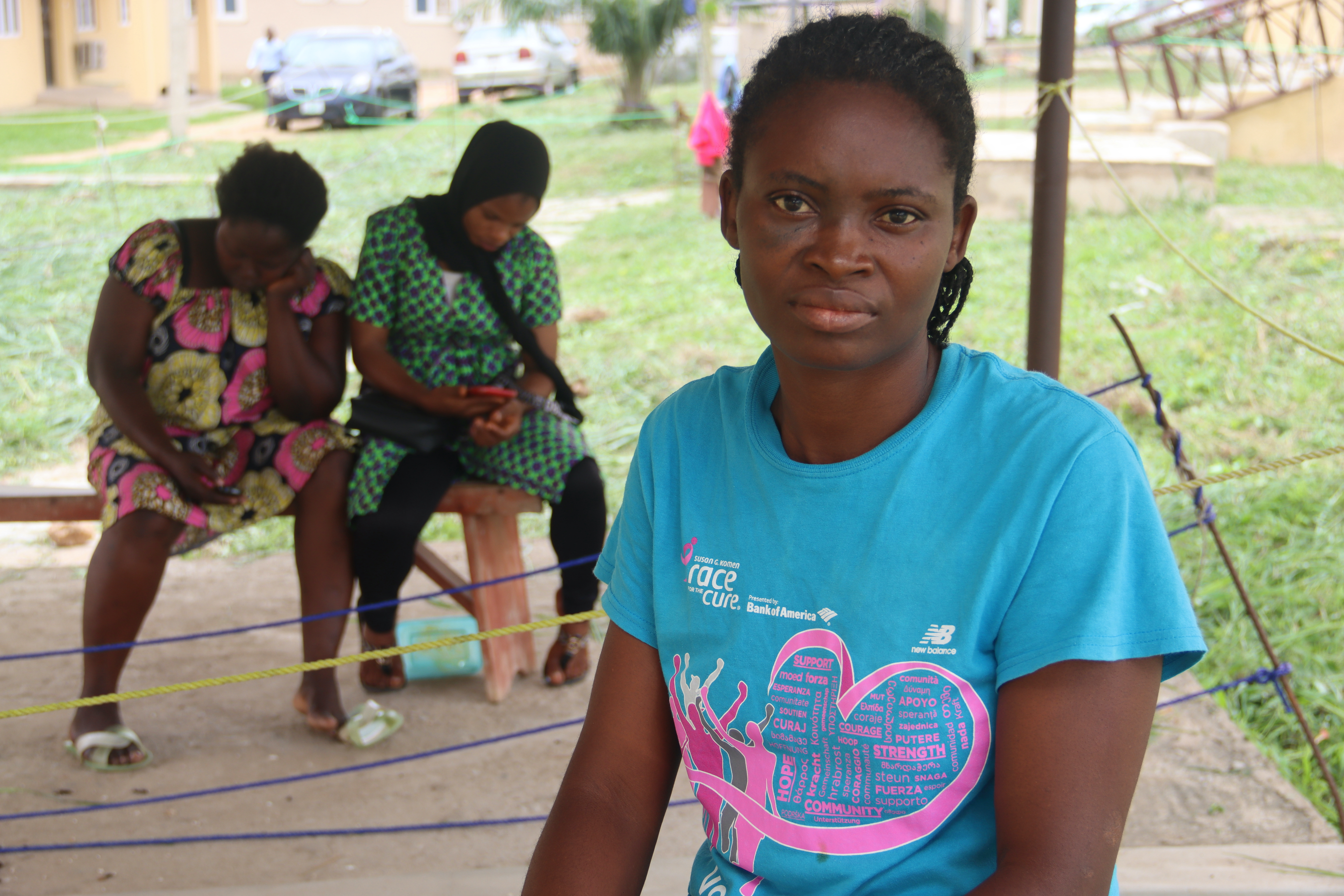 Mrs Kayode, a main character, in the patient area of the family visitor's room, a lean-to under which a ditch separates the sick from the healthy