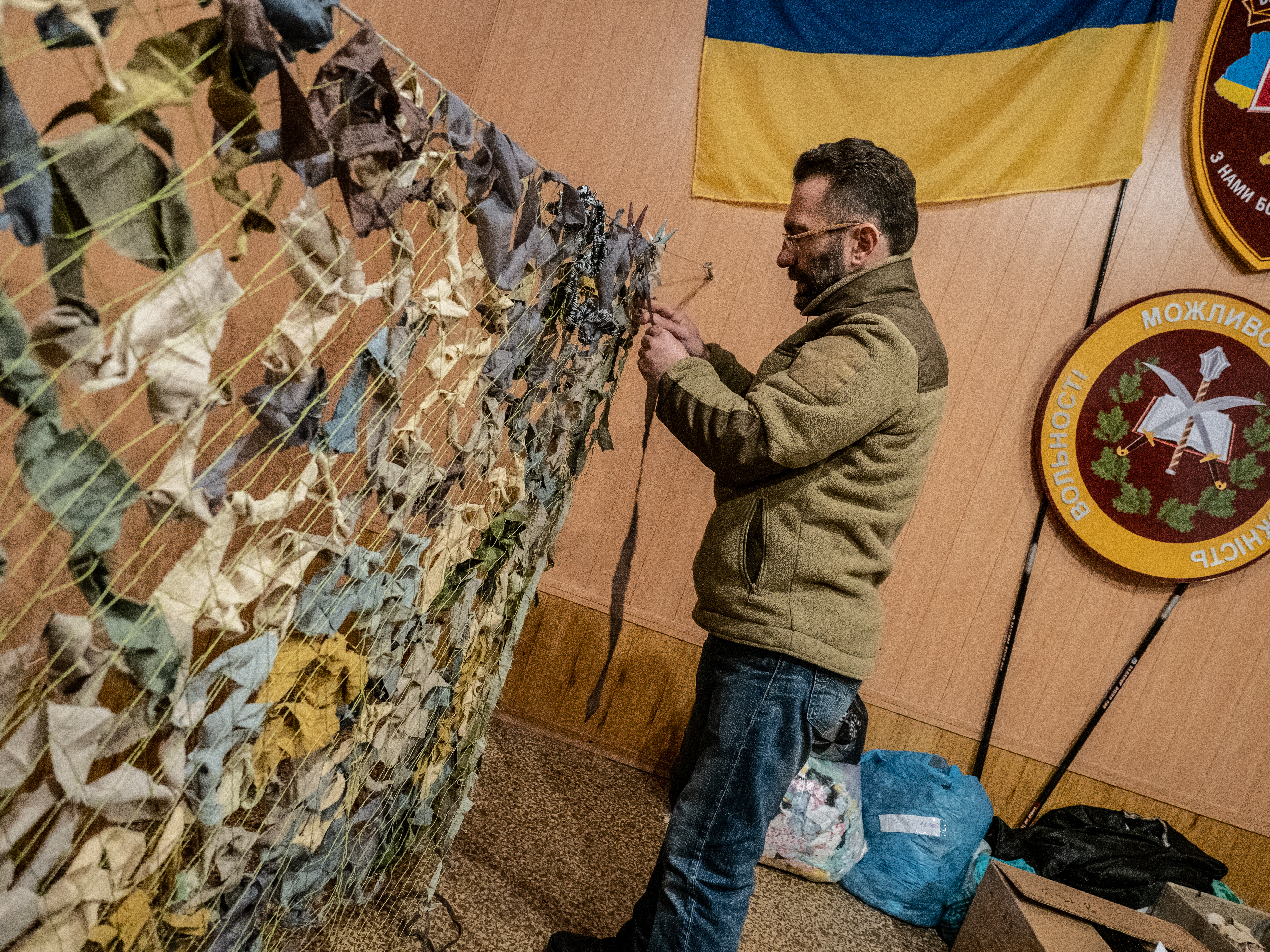 A photo of a man weaving camouflage.