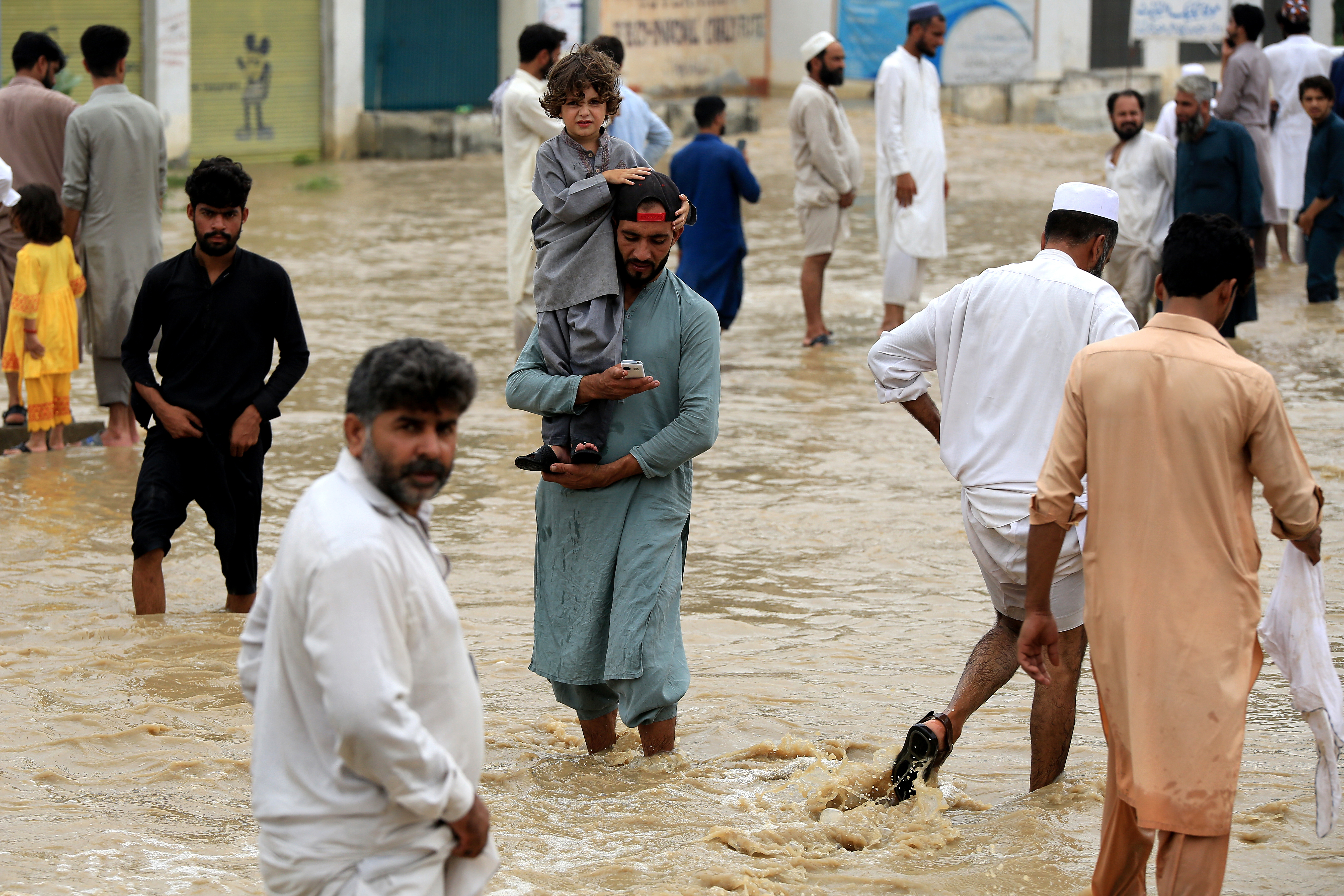 People wade through a flooded area