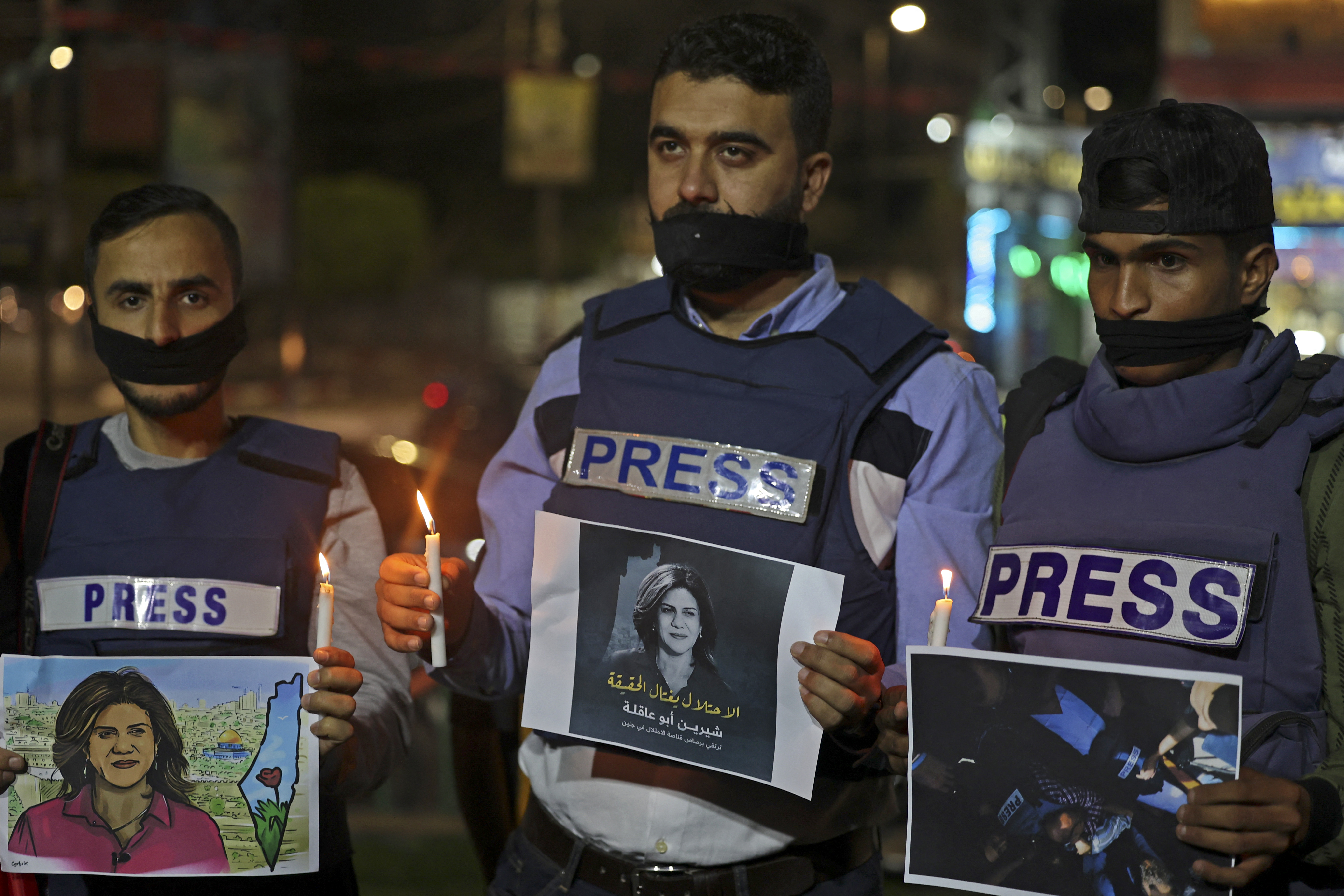 Journalists take part in a candlelight vigil to condemn the killing of veteran Al-Jazeera journalist Shireen Abu Akleh in Rafah in the southern Gaza Strip on May 11, 2022.