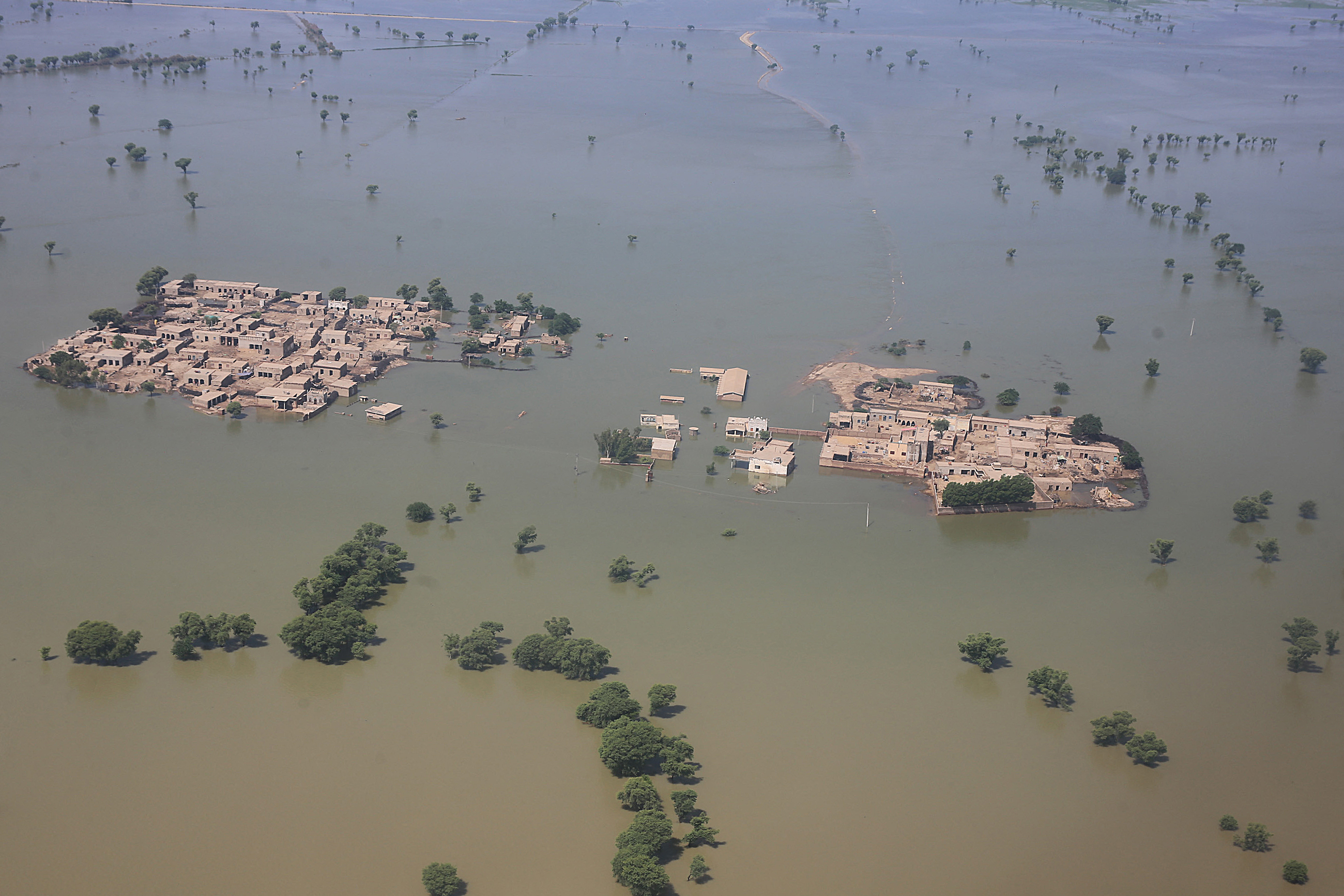 An aerial photograph shows a flooded residential area in Dadu district of Sindh.